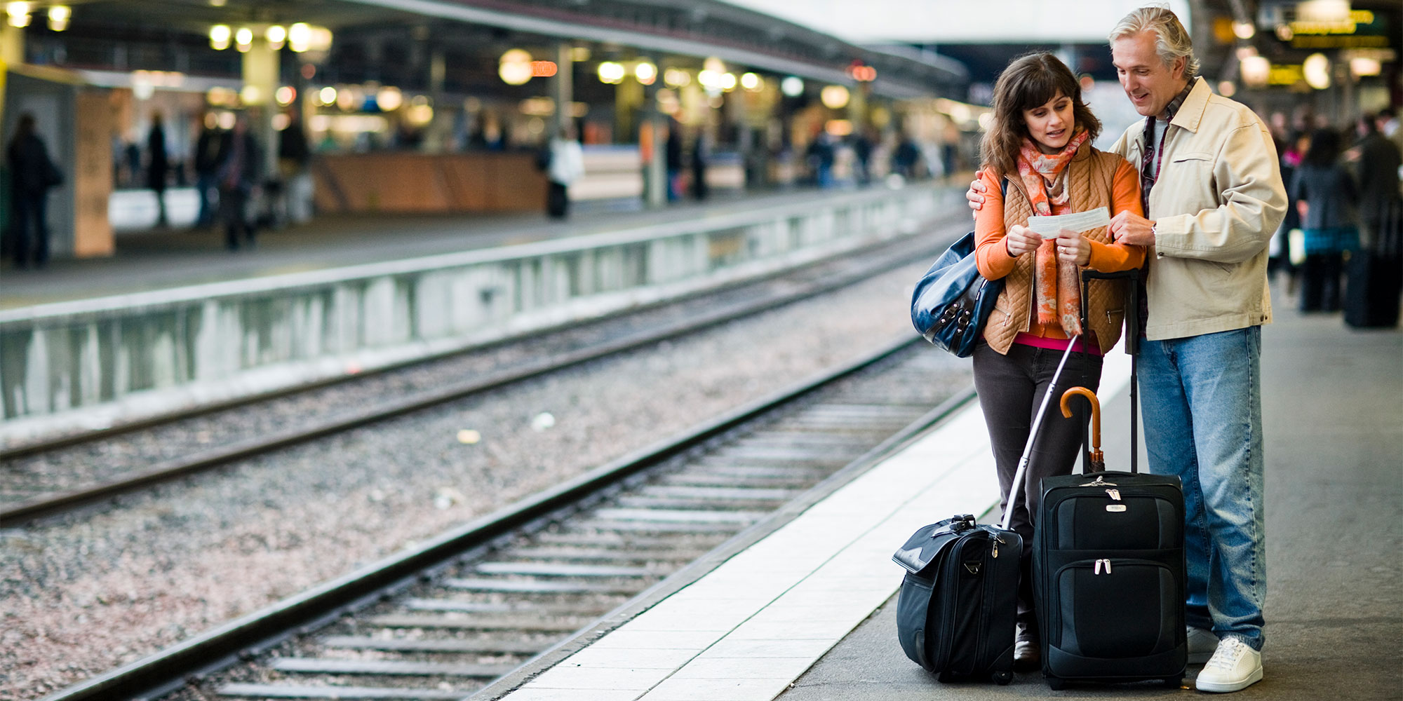 Two travellers checking their train tickets on holiday