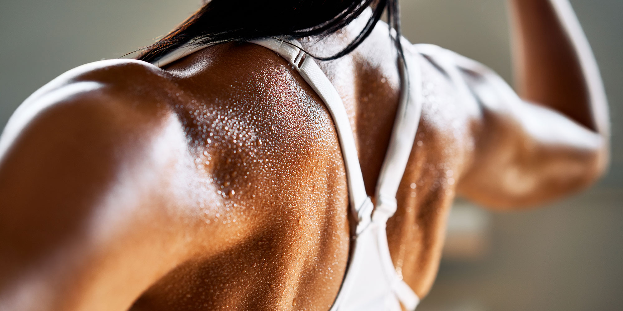 An impressively muscled person sweating during a workout