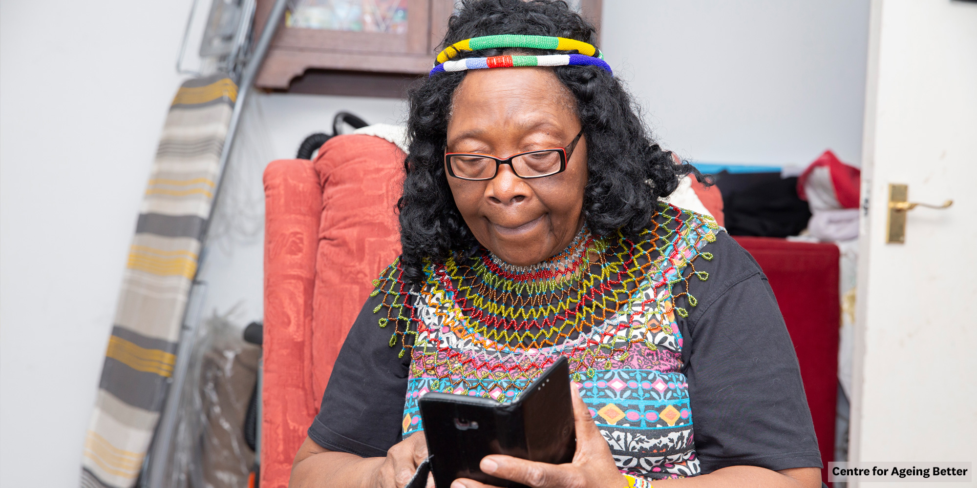 A woman sitting in a chair using a mobile phone