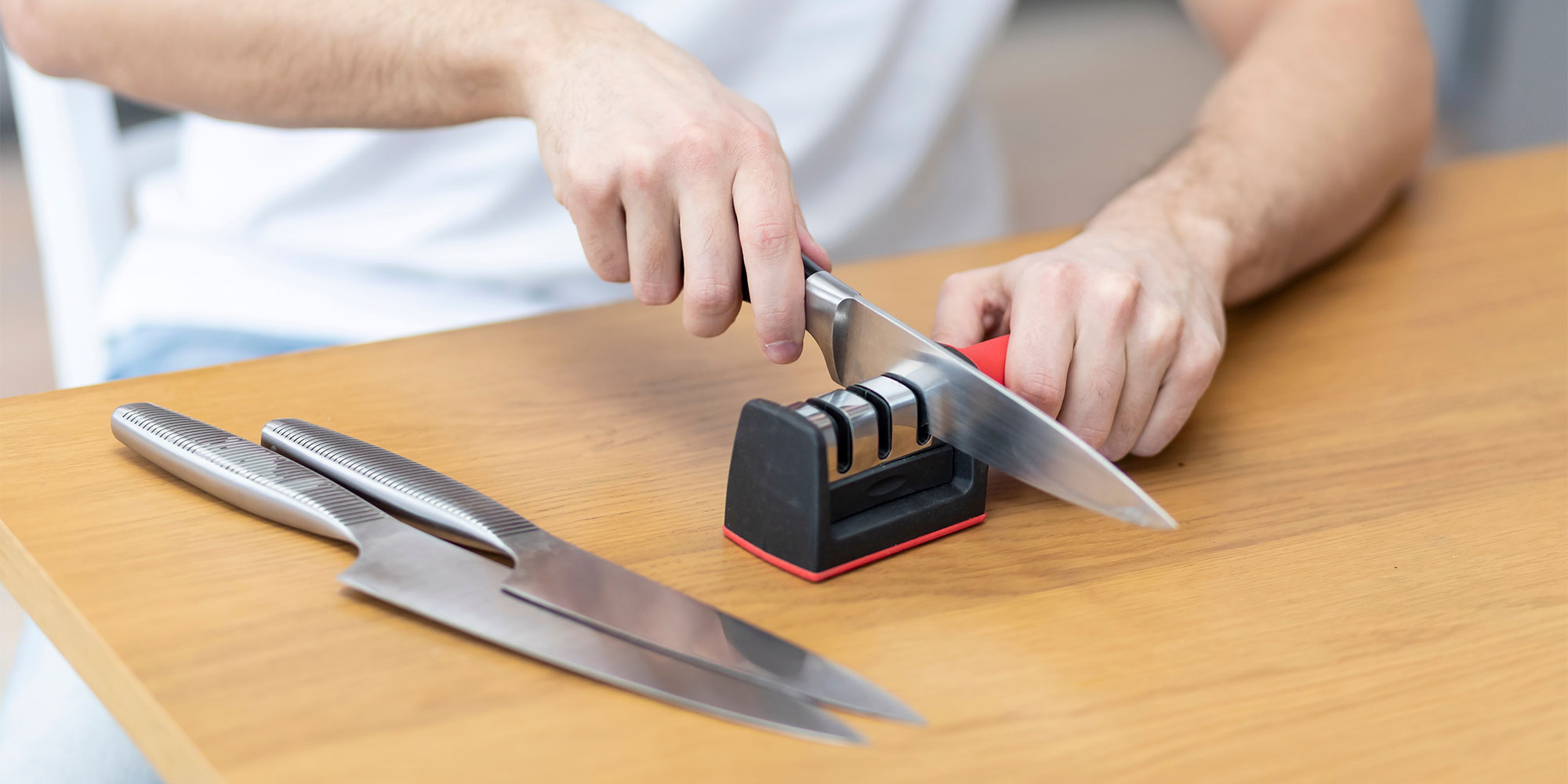 Knife being sharpened using pull-through knife sharpener