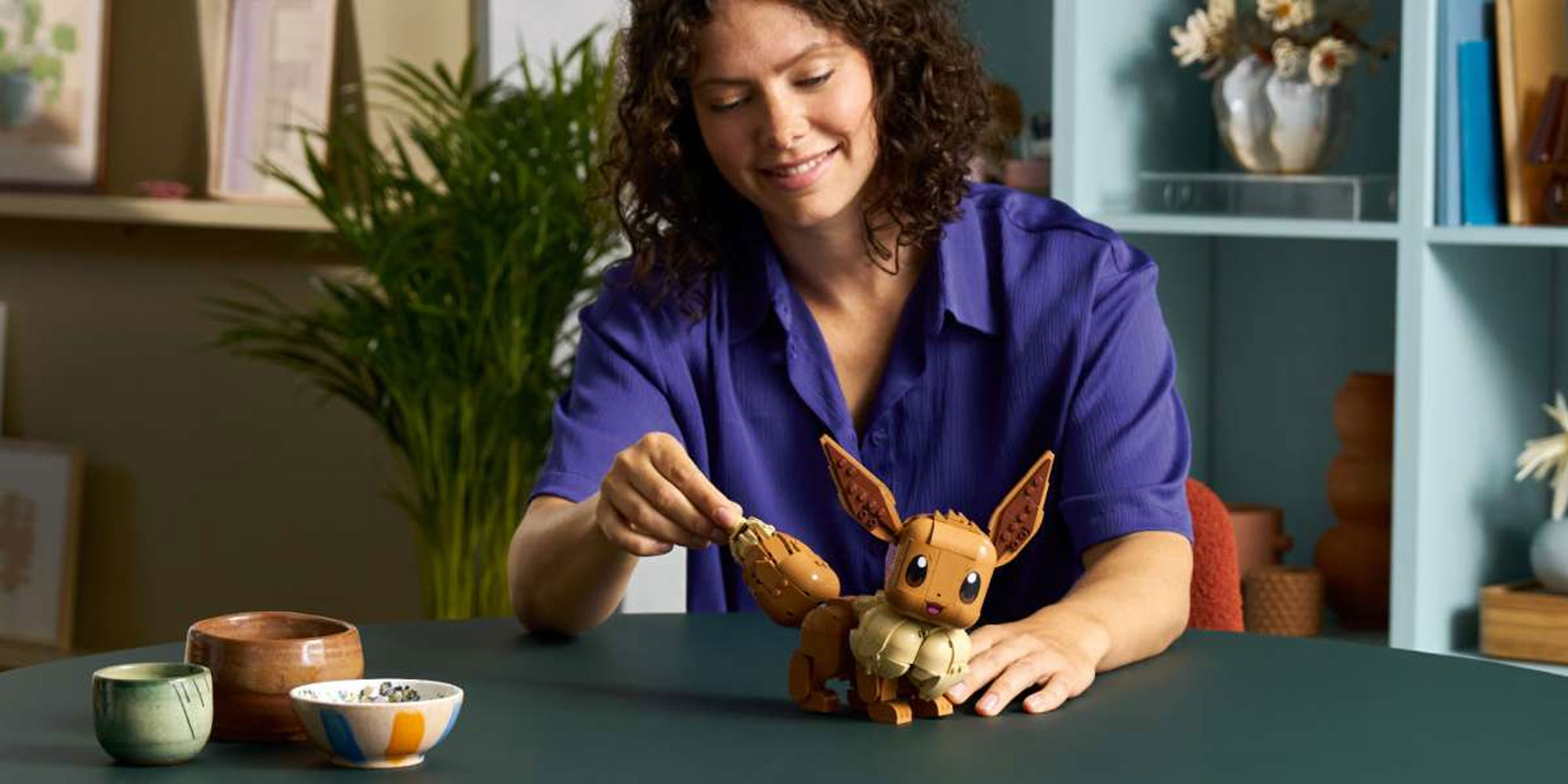 A woman building a Lego Eevee