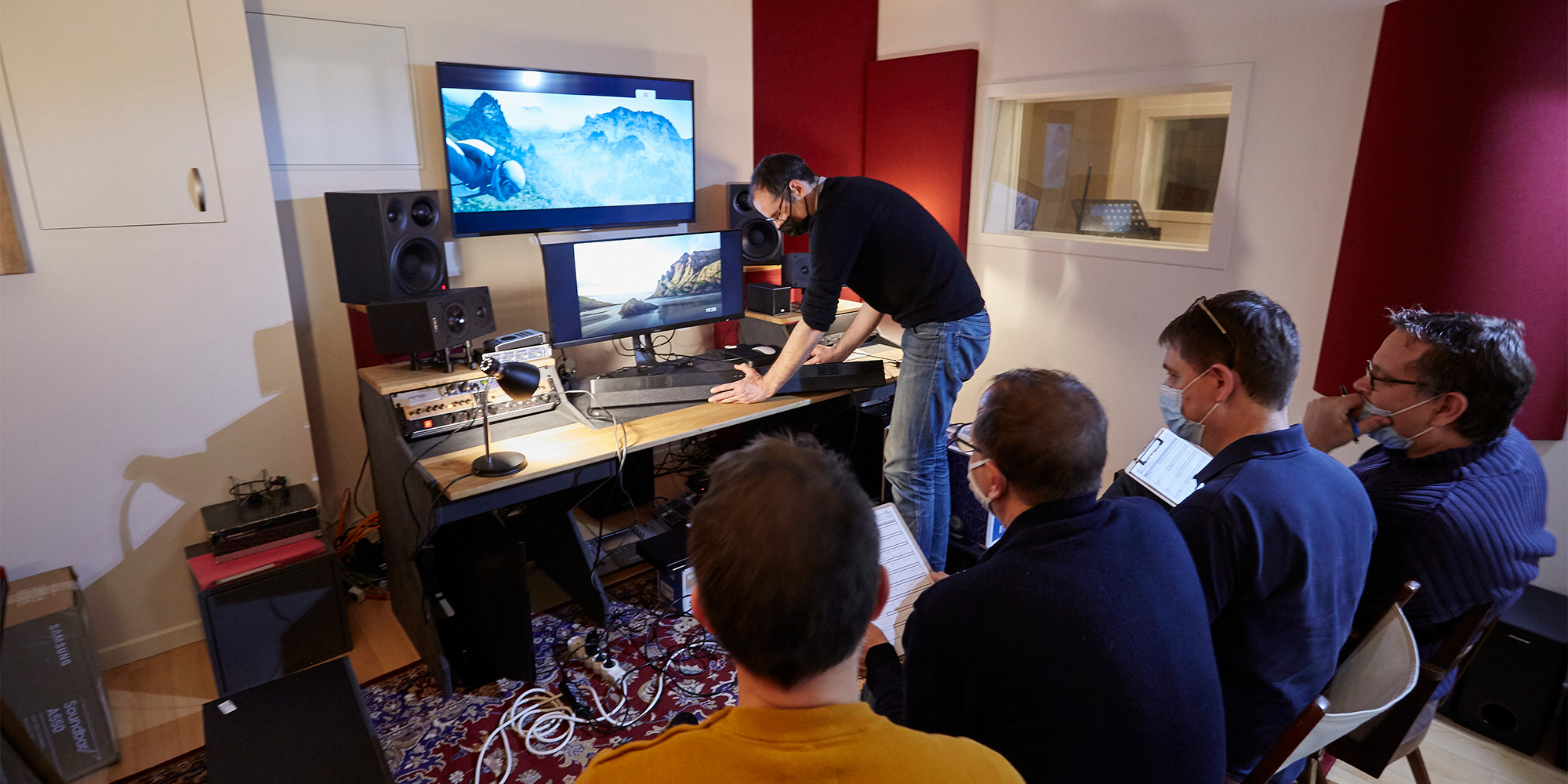 Five people in a sound booth assessing the sound quality of a soundbar.