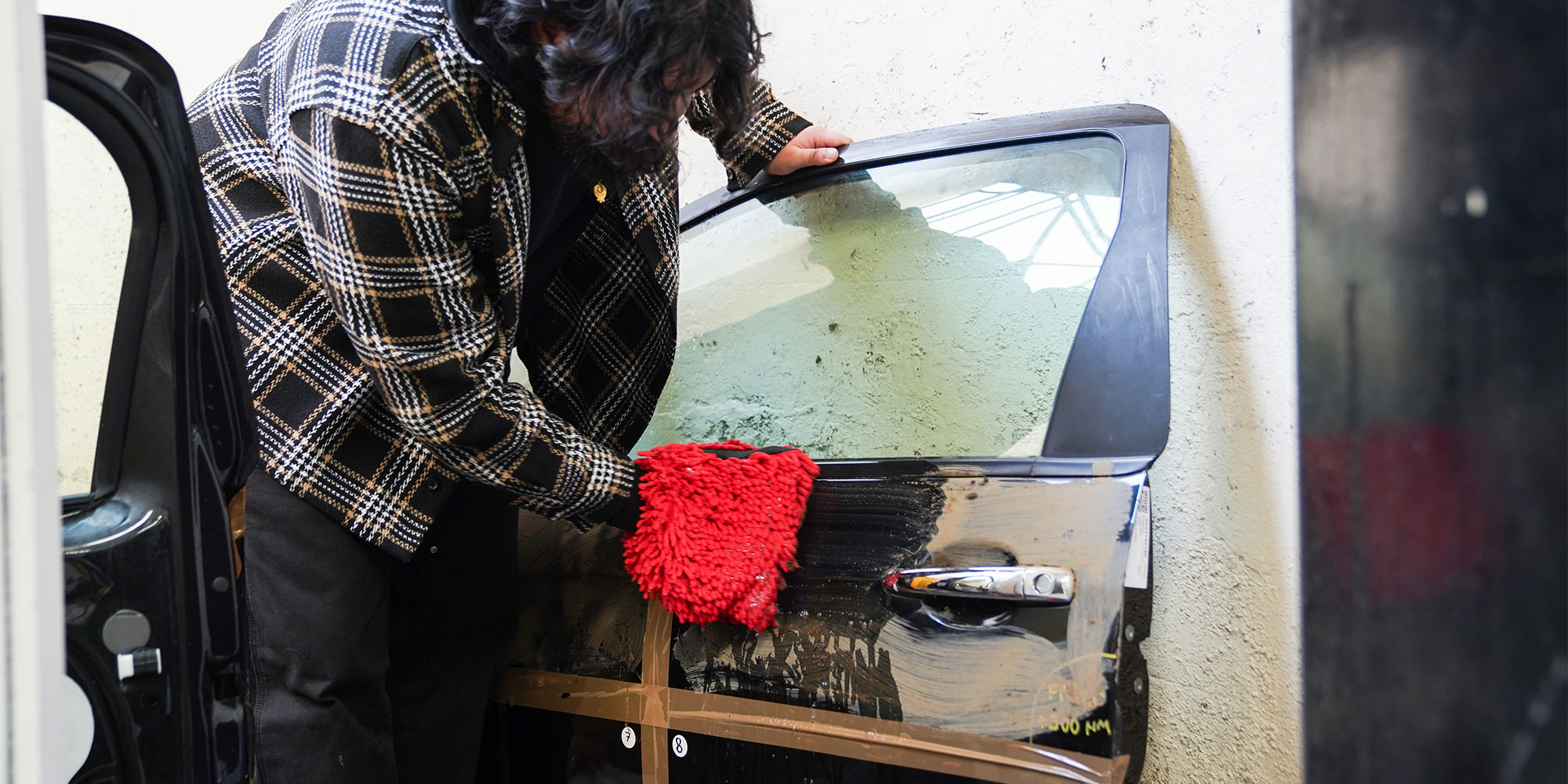 Mud being cleaned away with a wash mit and shampoo by Which? cleaning expert.