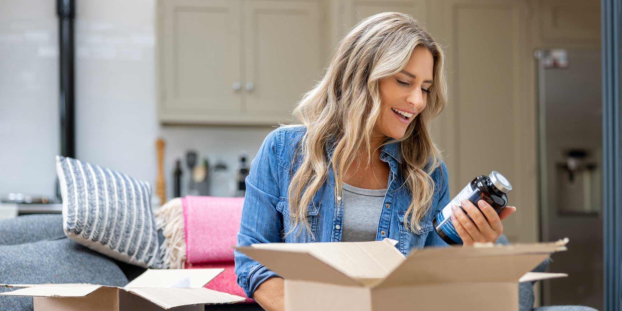 Woman opening a box including supplements and examining the label
