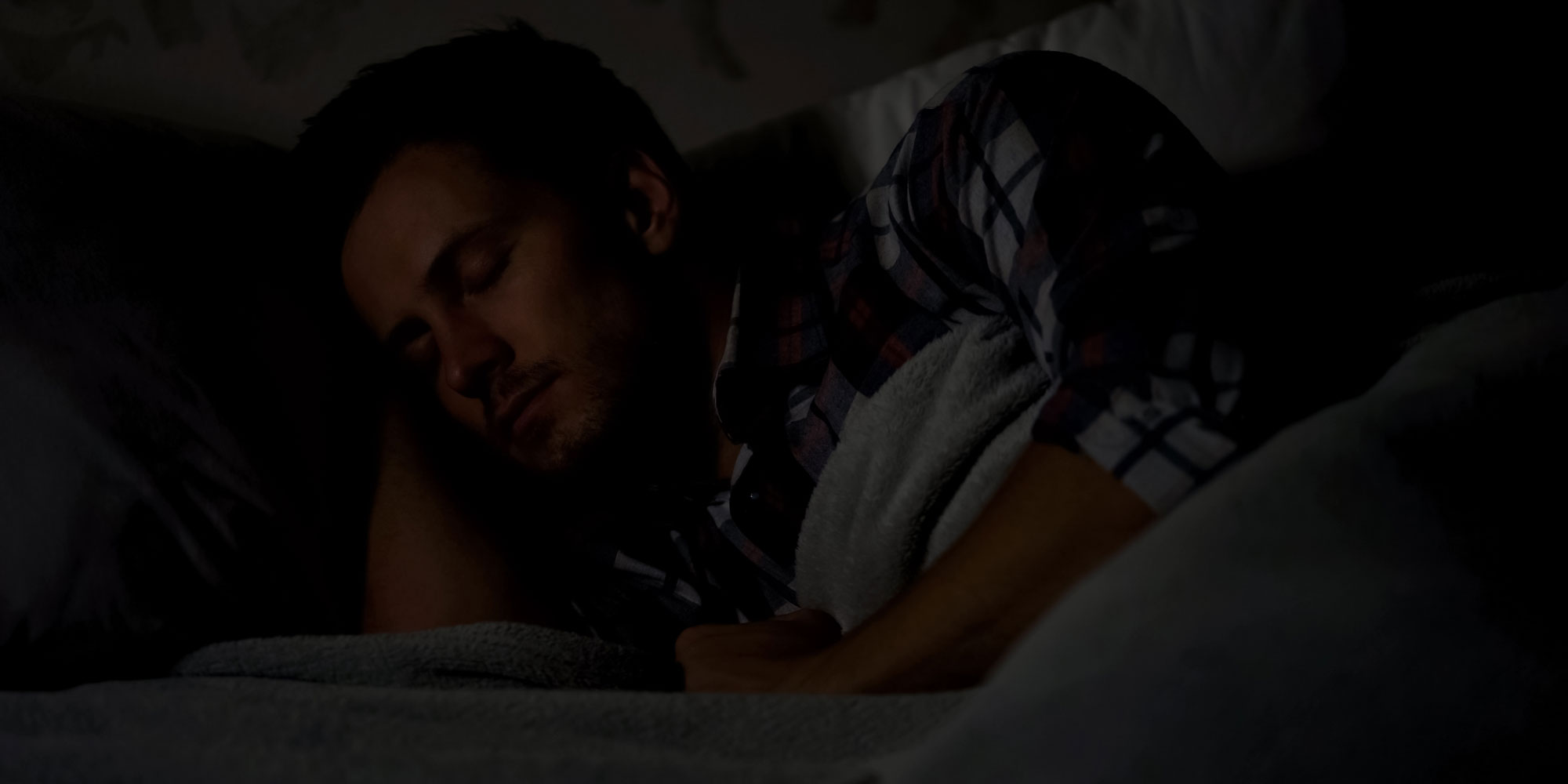 A man sleeping in a dark room