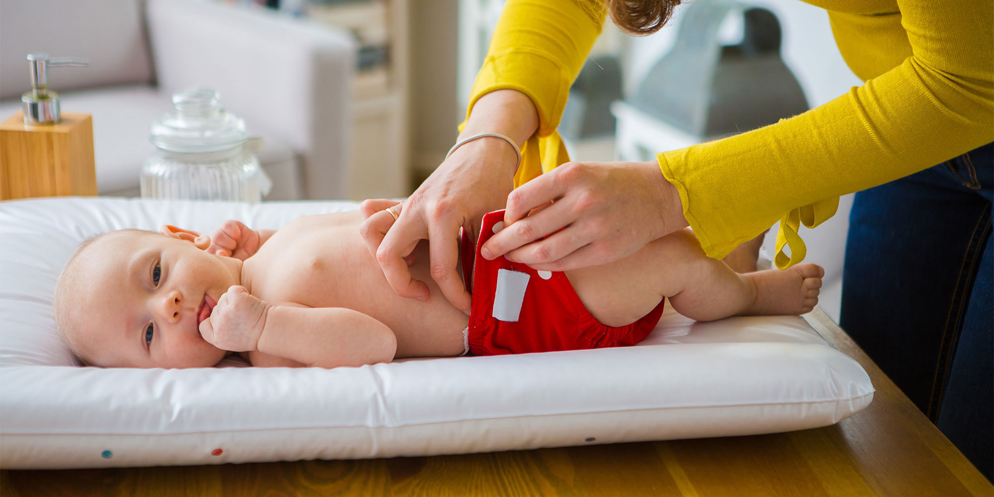 Woman changing reusable nappy on a baby