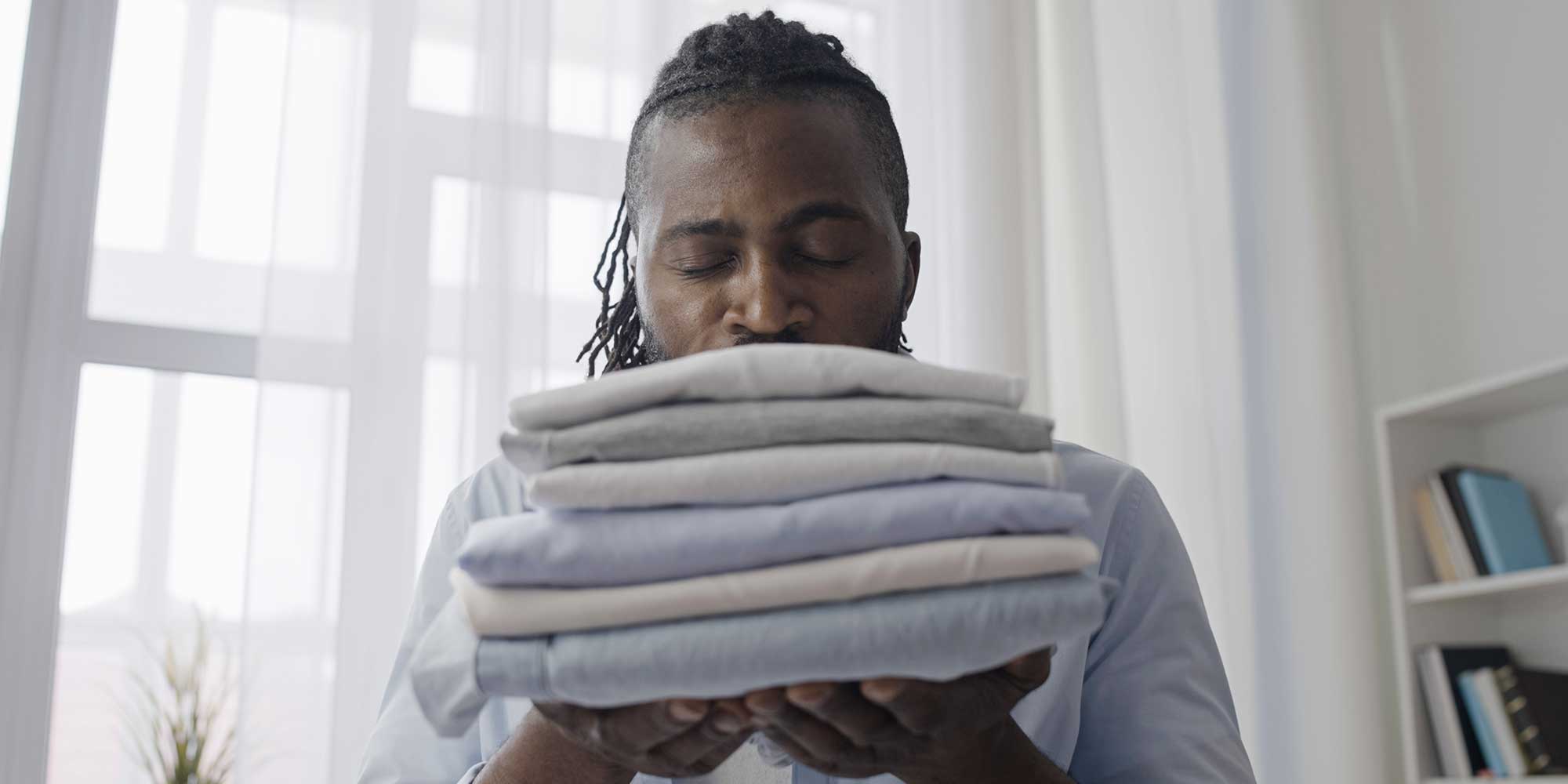 Person sniffing stack of towels