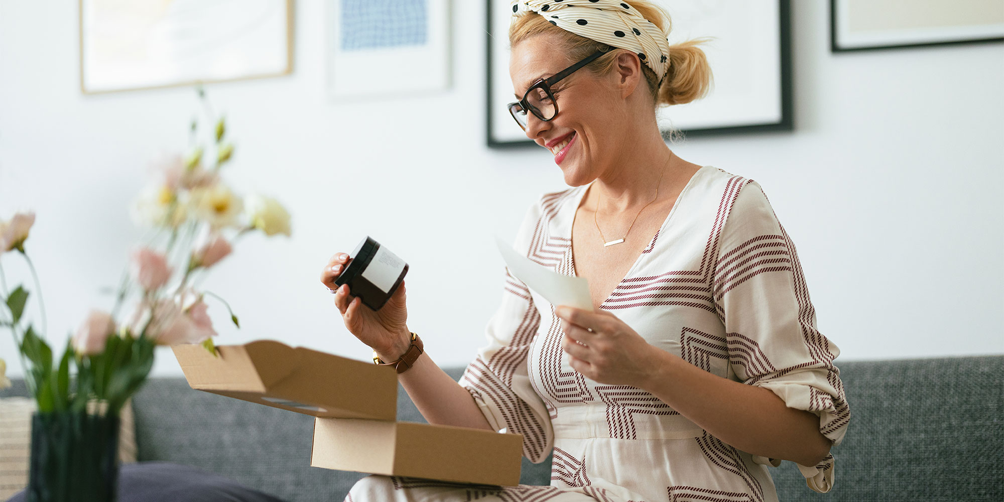 A woman looking at the label of a jar or beauty product