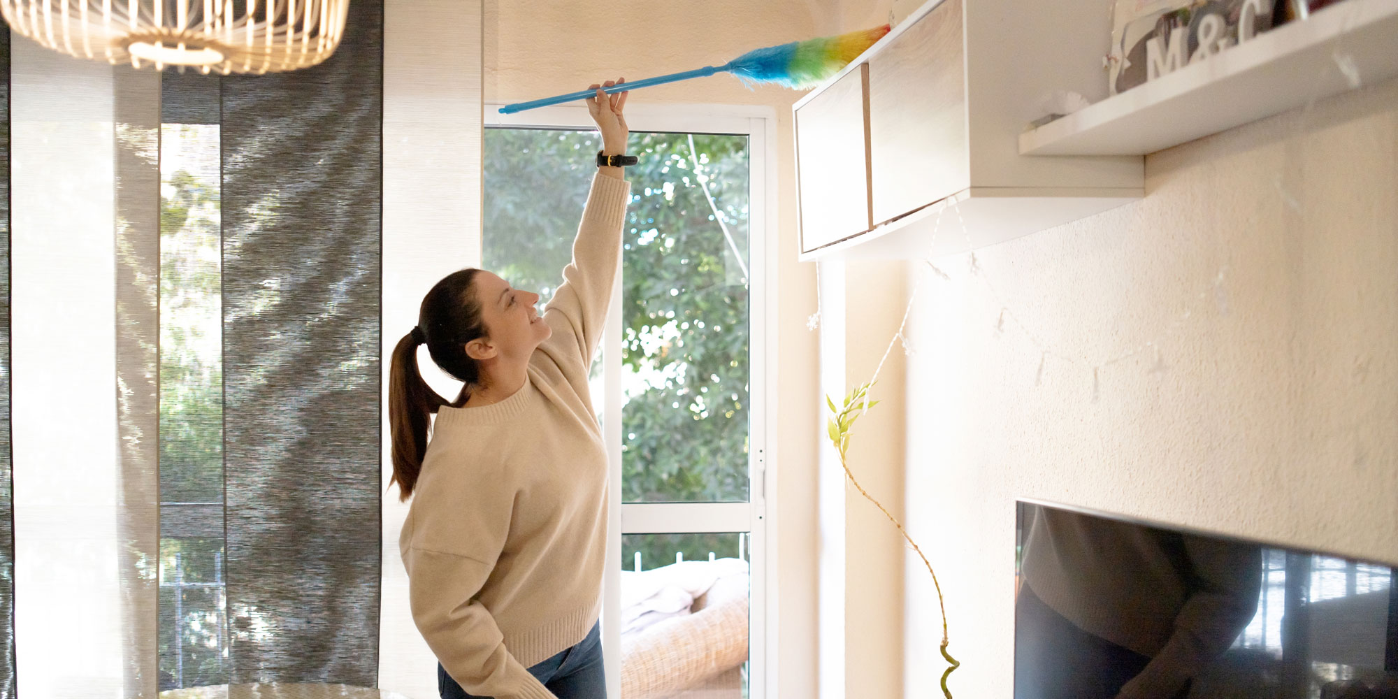 Using a feather dusting to clean high up
