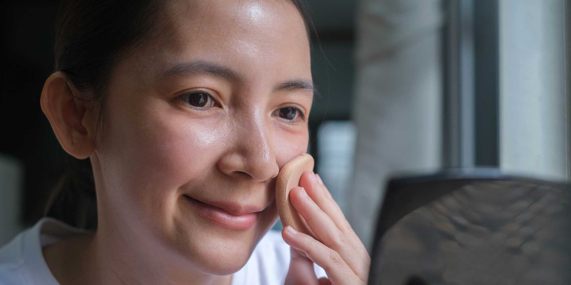 Woman applying foundation make up