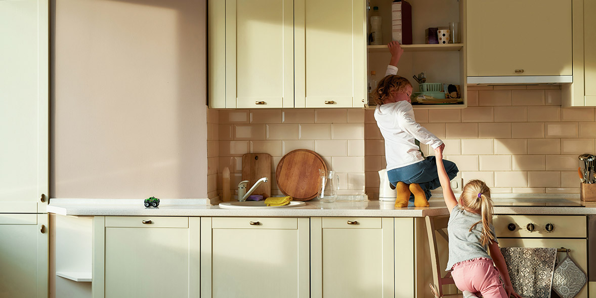 Two girls looking in kitchen cabinets