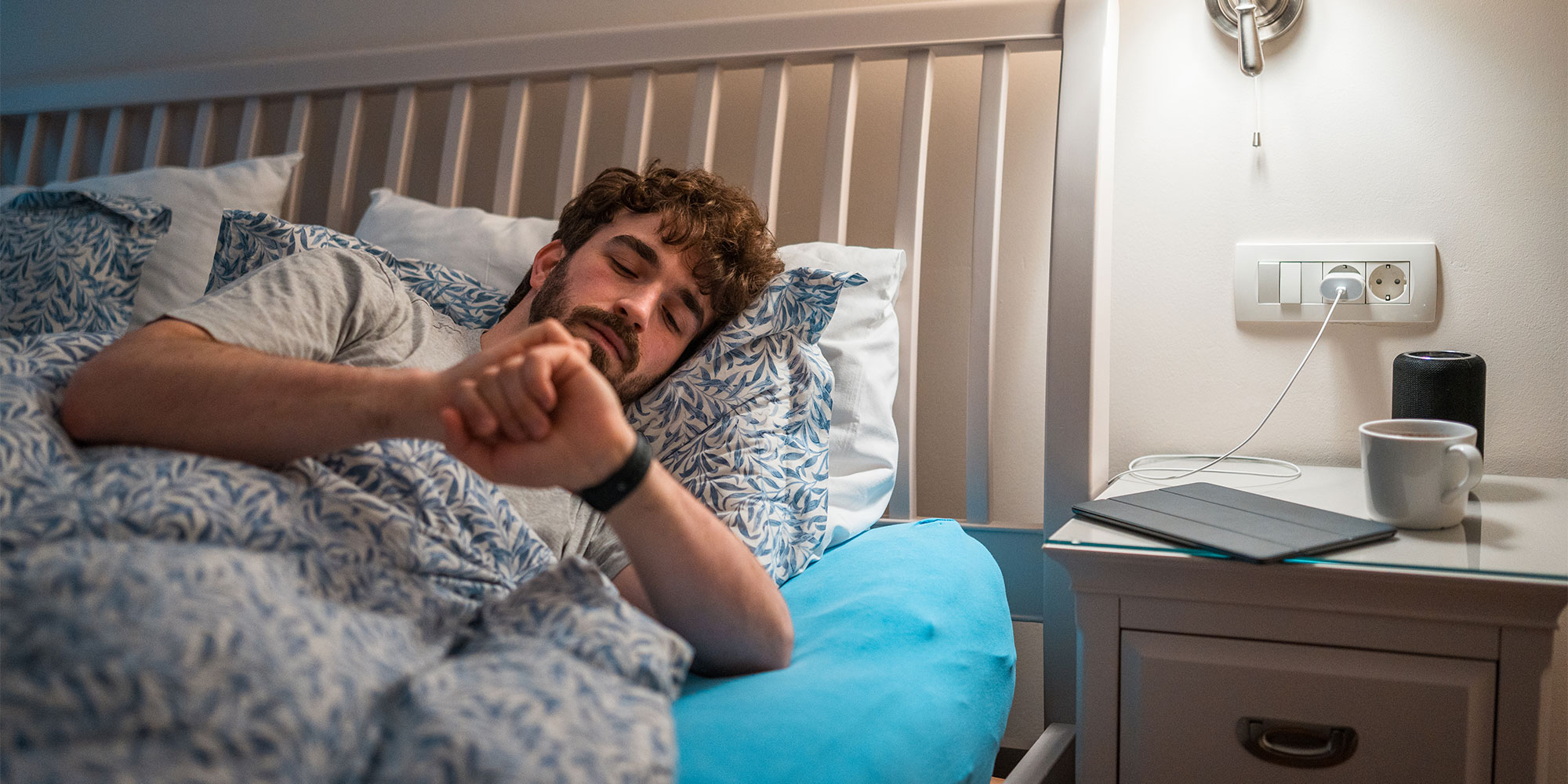 Man checking smartwatch in bed