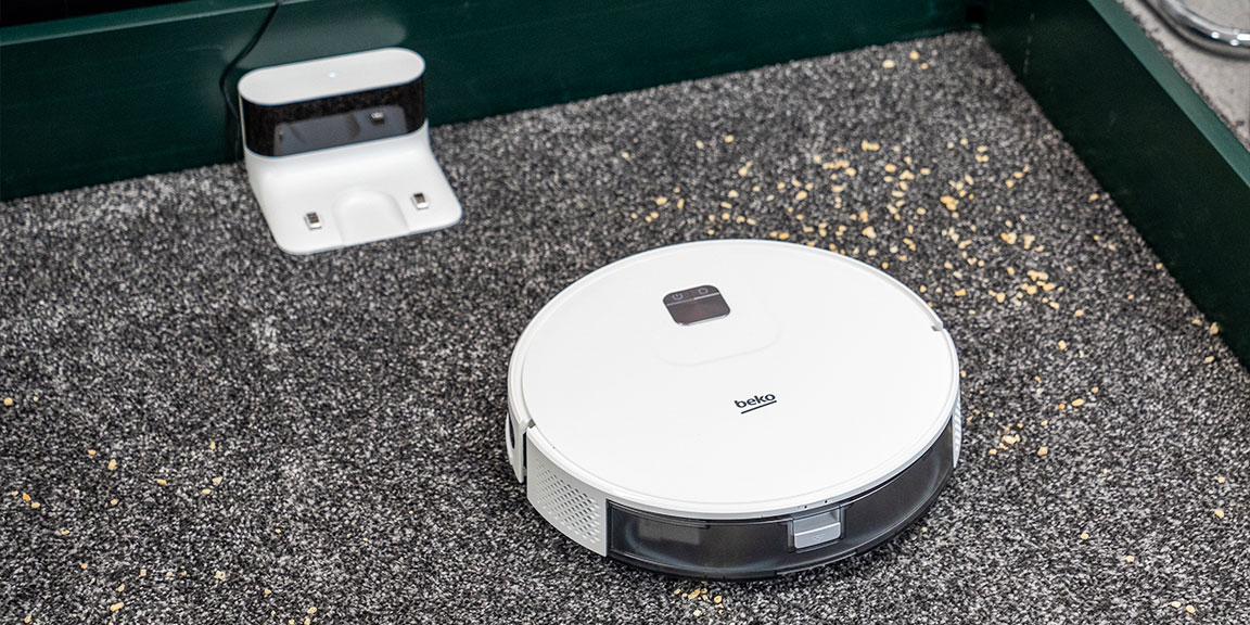 Robot vacuum working on carpet suctioning lentils 