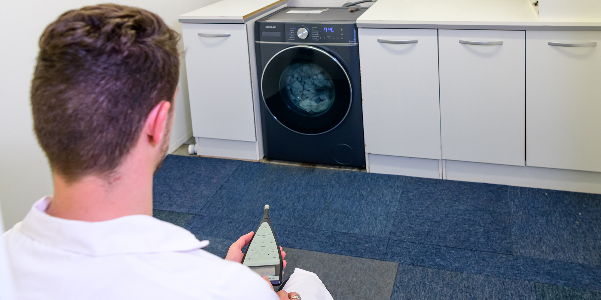 A panel of three technicians monitor how loud each machine is as it washes, rinses and dries using a decibel monitoring device.
