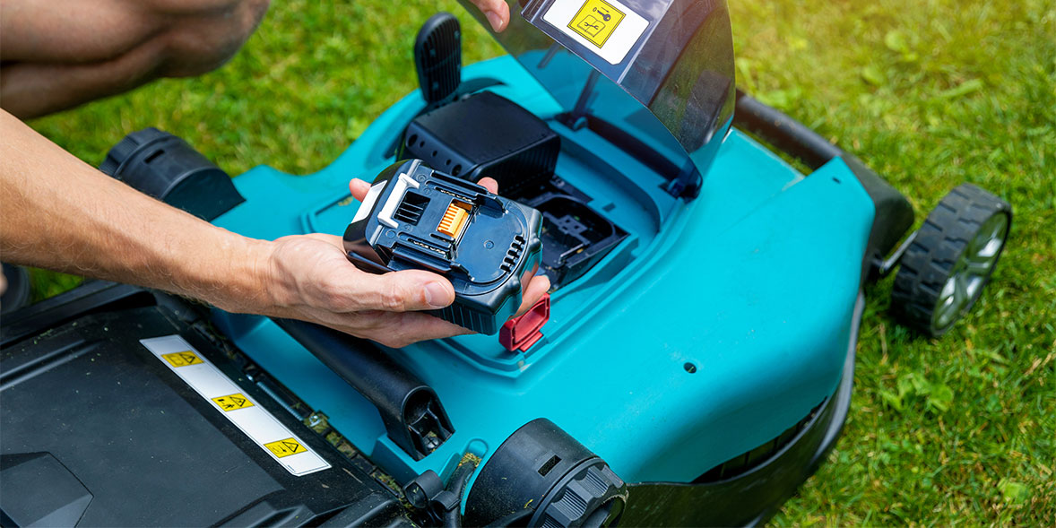 Someone replacing a mower battery