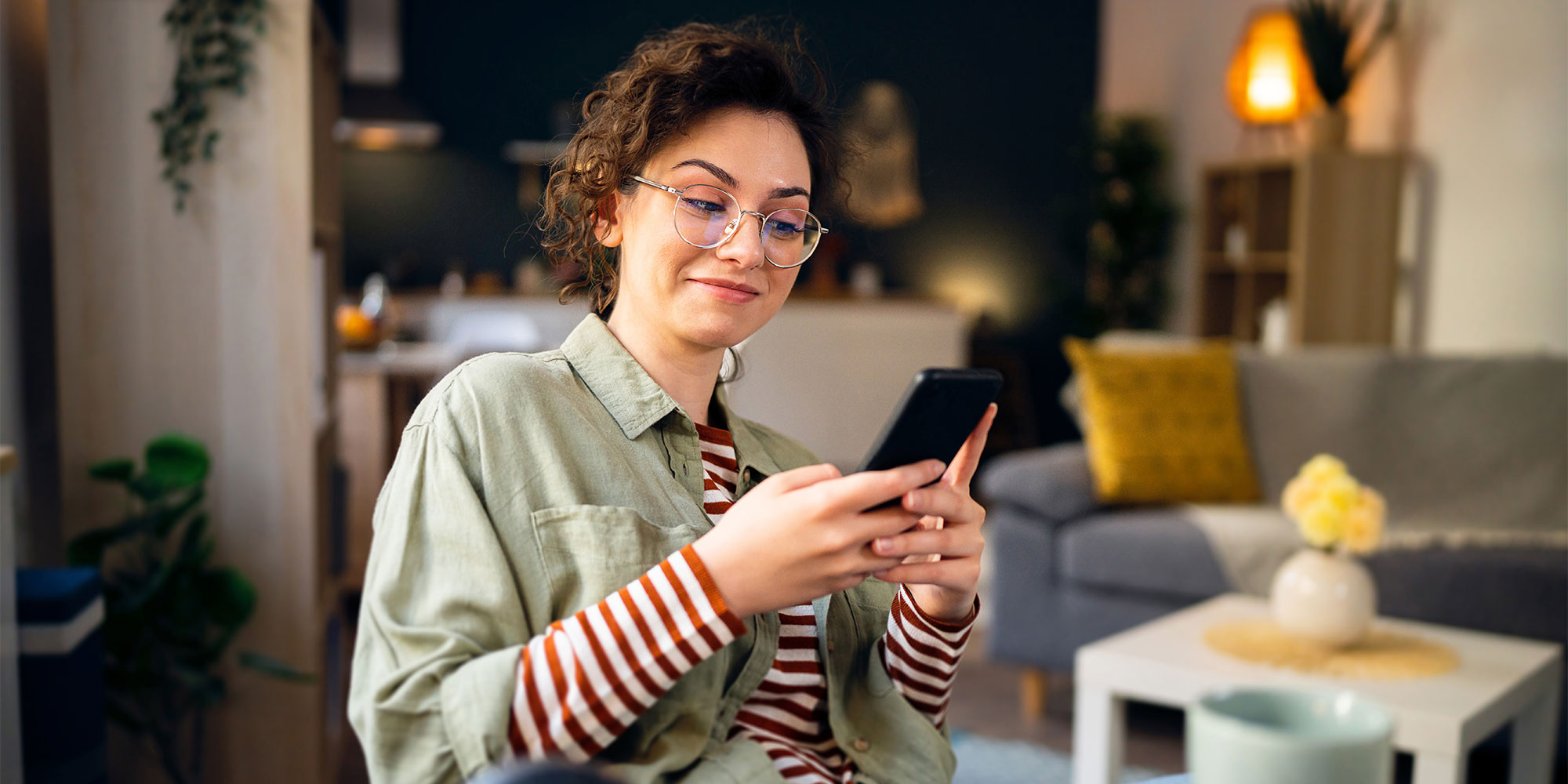 A person reading something on their phone with a smirk. 