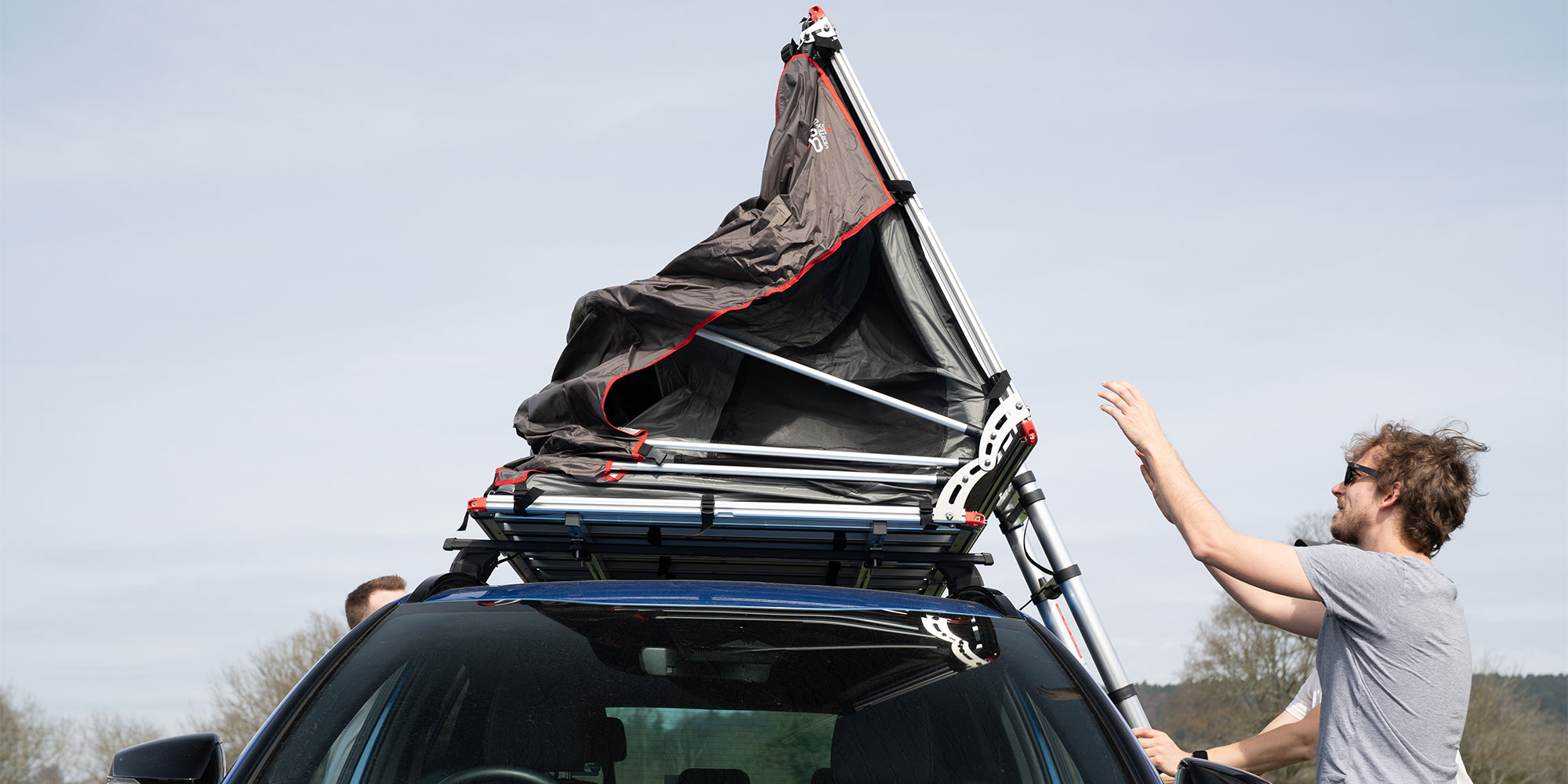 Folding a roof tent at a campsite