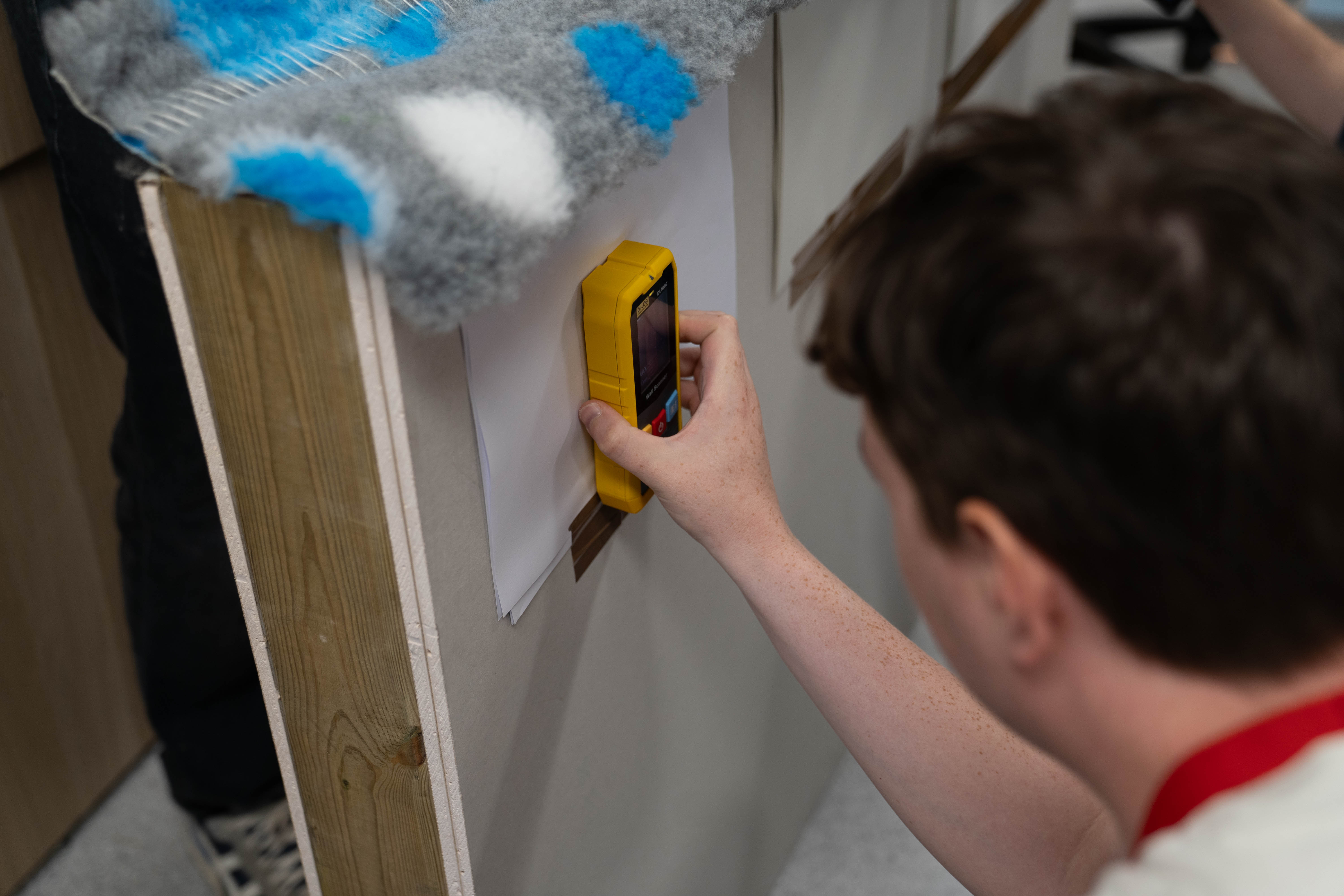 Using a stud locator on the custom-built wall in the Which? testing room.