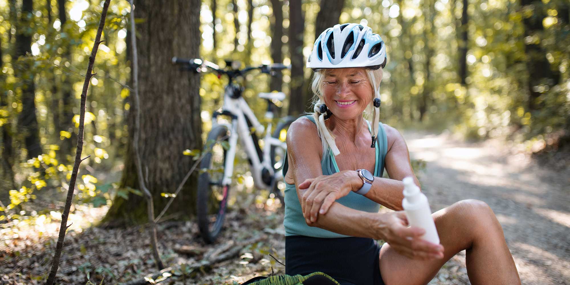 Woman applying sun cream during a bike ride