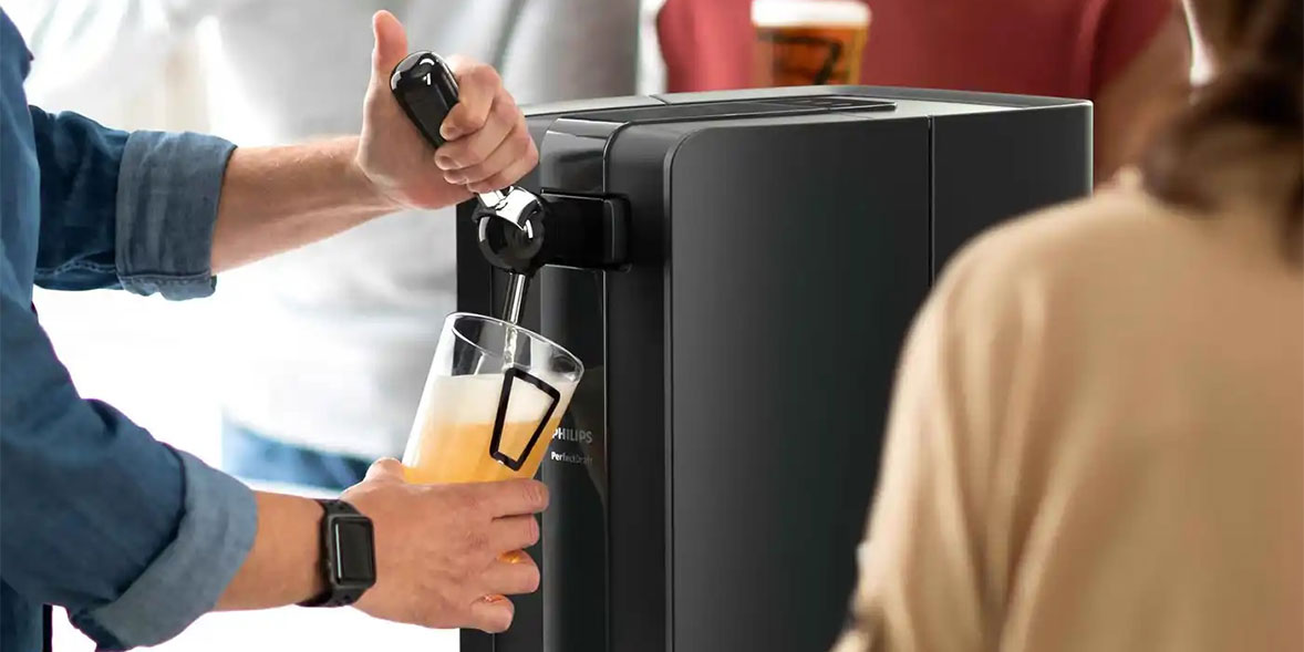 Someone using a Philips Perfectdraft machine