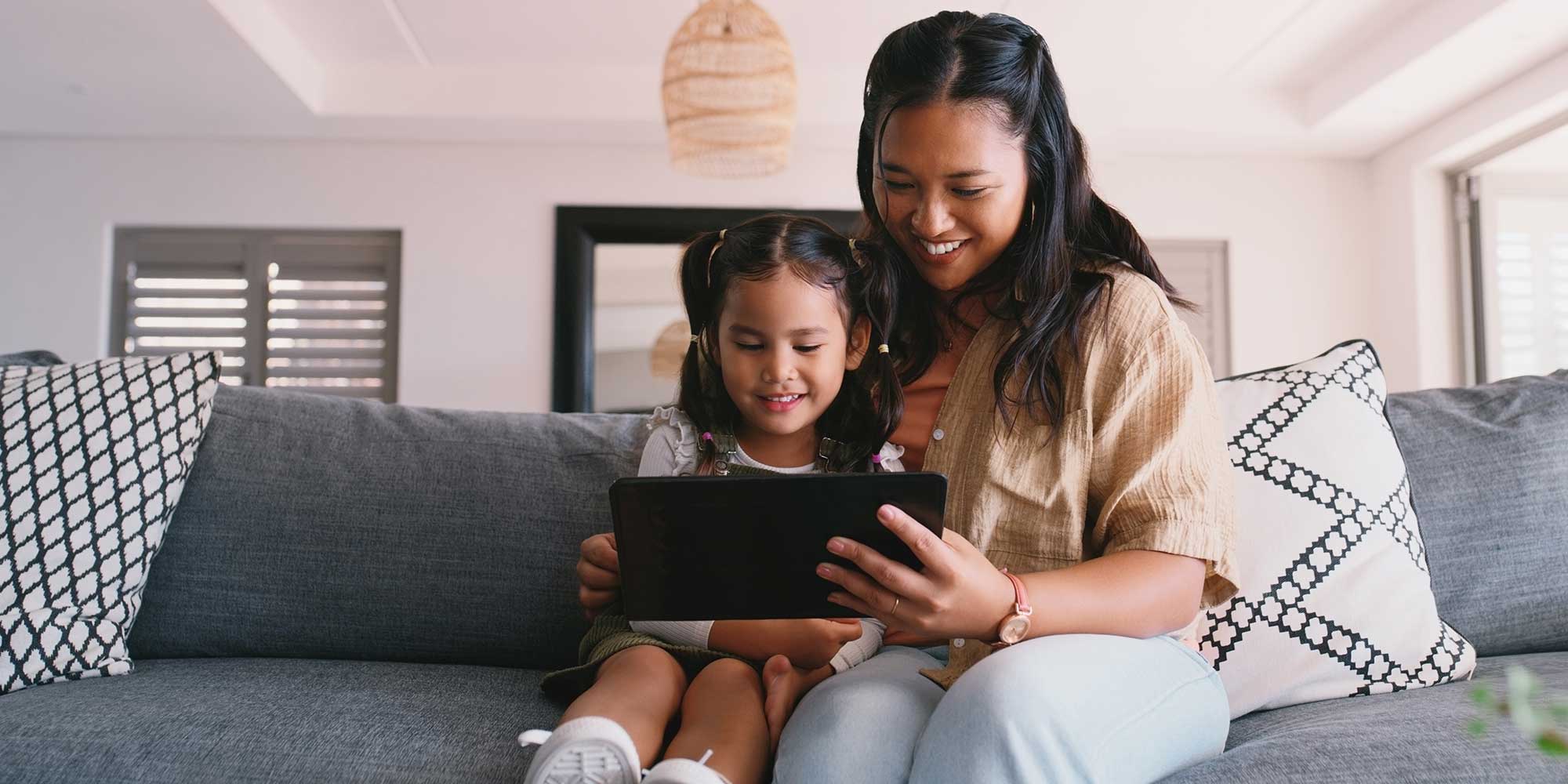 Mother and child reading from an e-reader