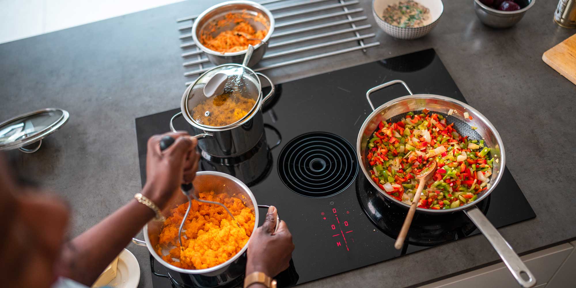 Venting hob from above, with three dishes cooking and the vent in the middle