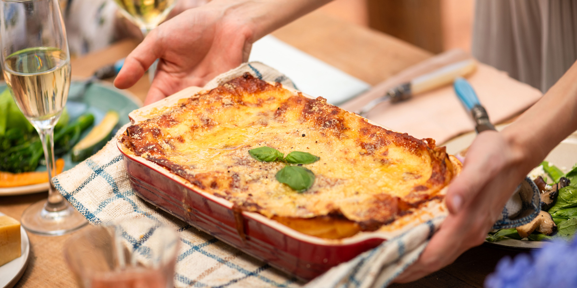 a person serving a lasagne