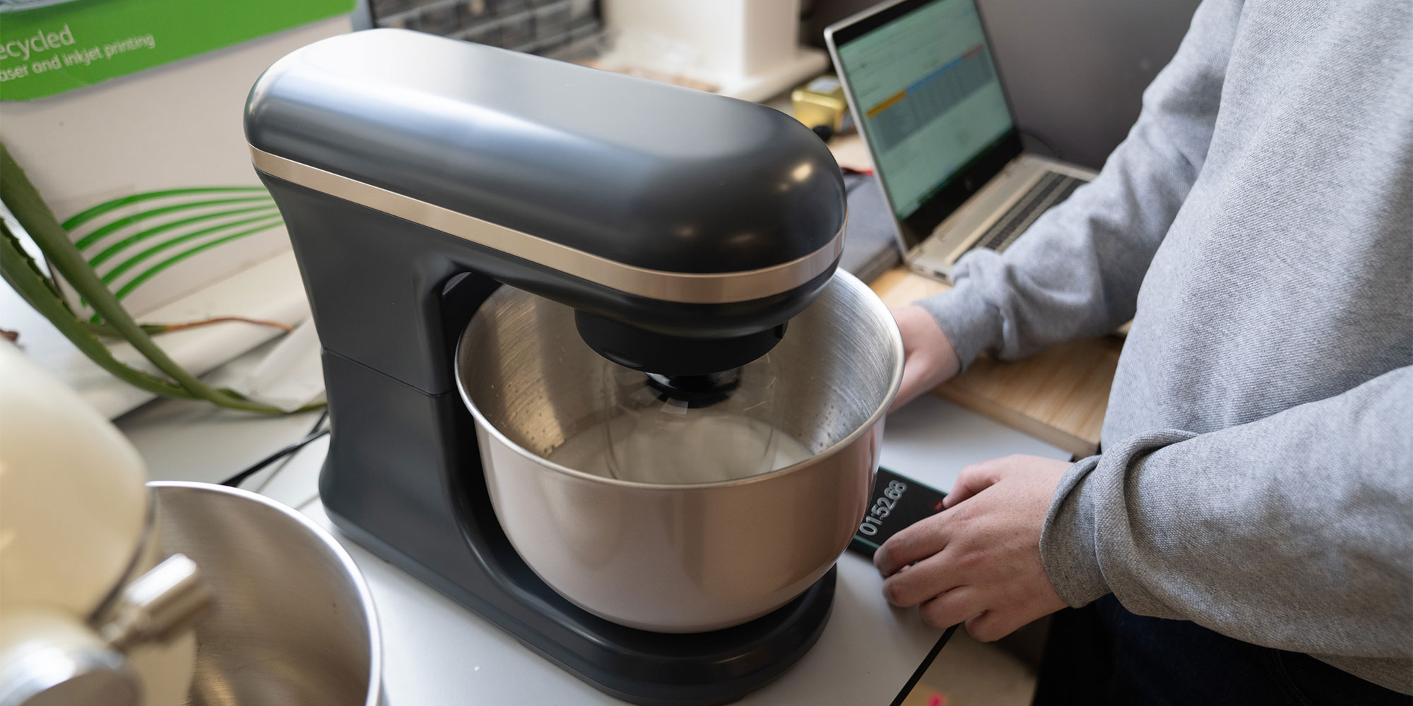 One of our testers timing how long a mixer takes to whisk egg whites.