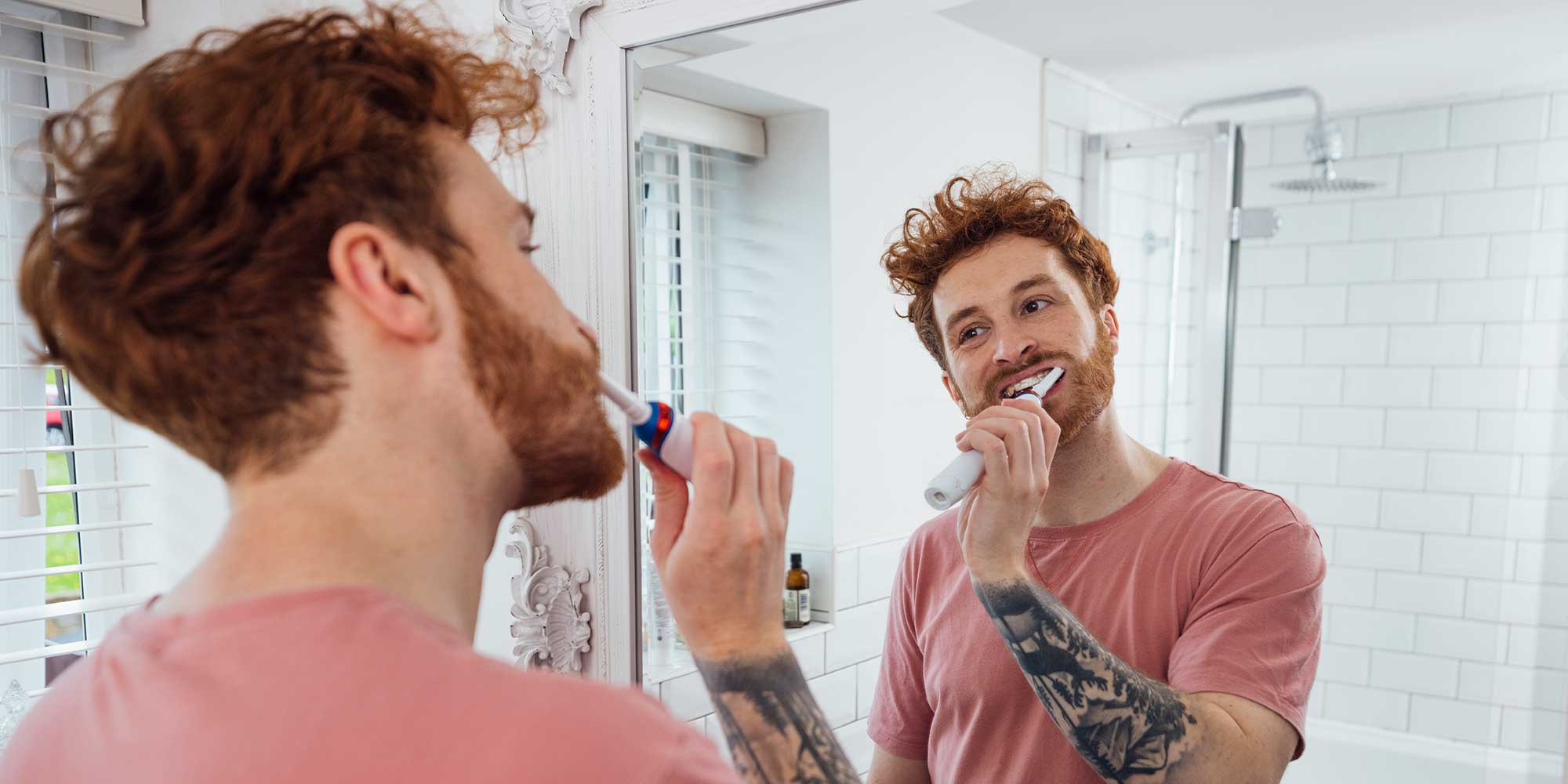 person brushing their teeth with an electric toothbrush