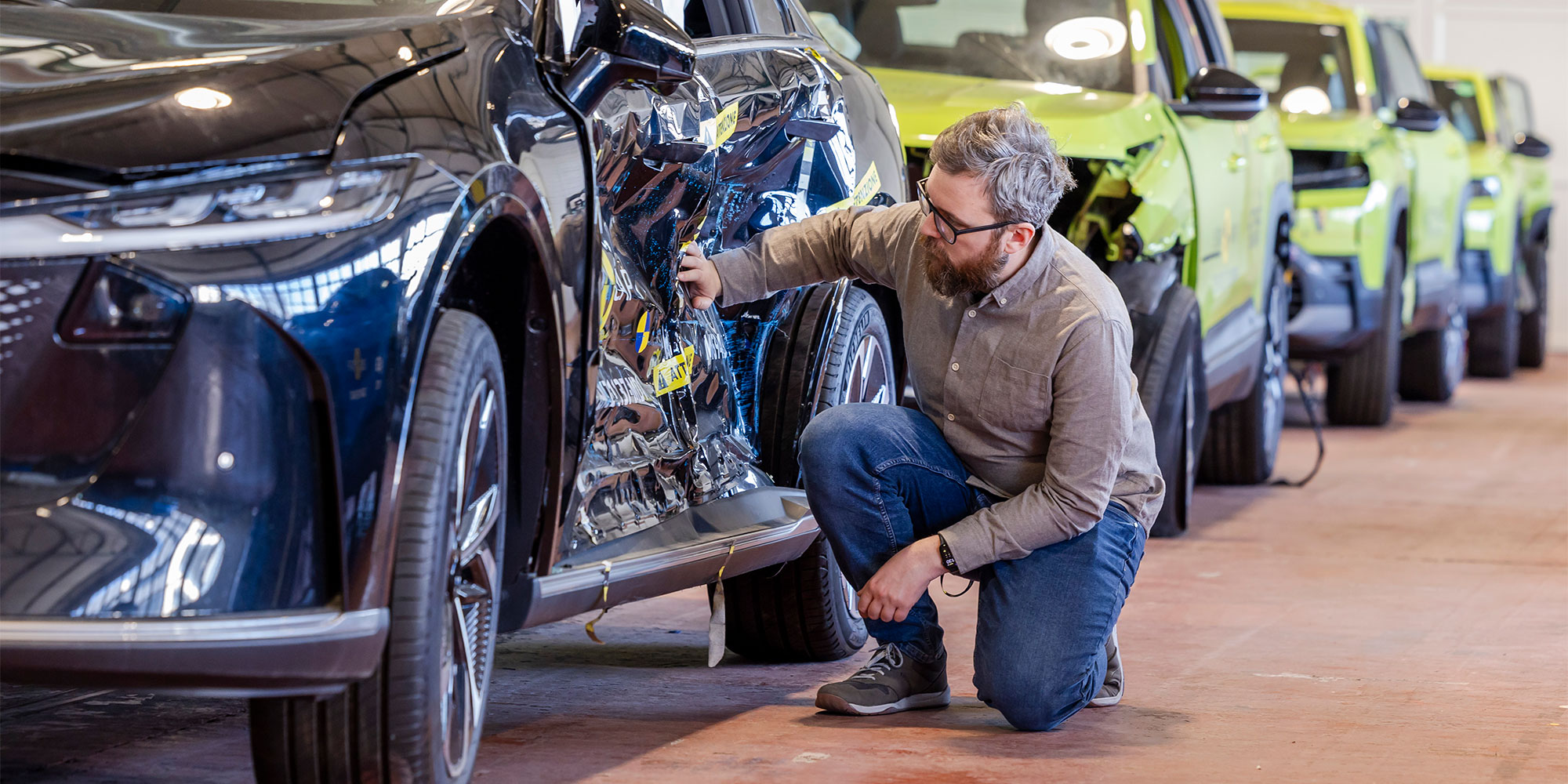 Man looking at dent in car after Euro NCAP crash test