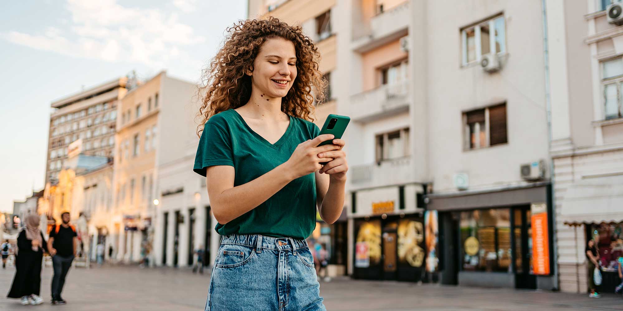 A person walking down the street on their mobile phone