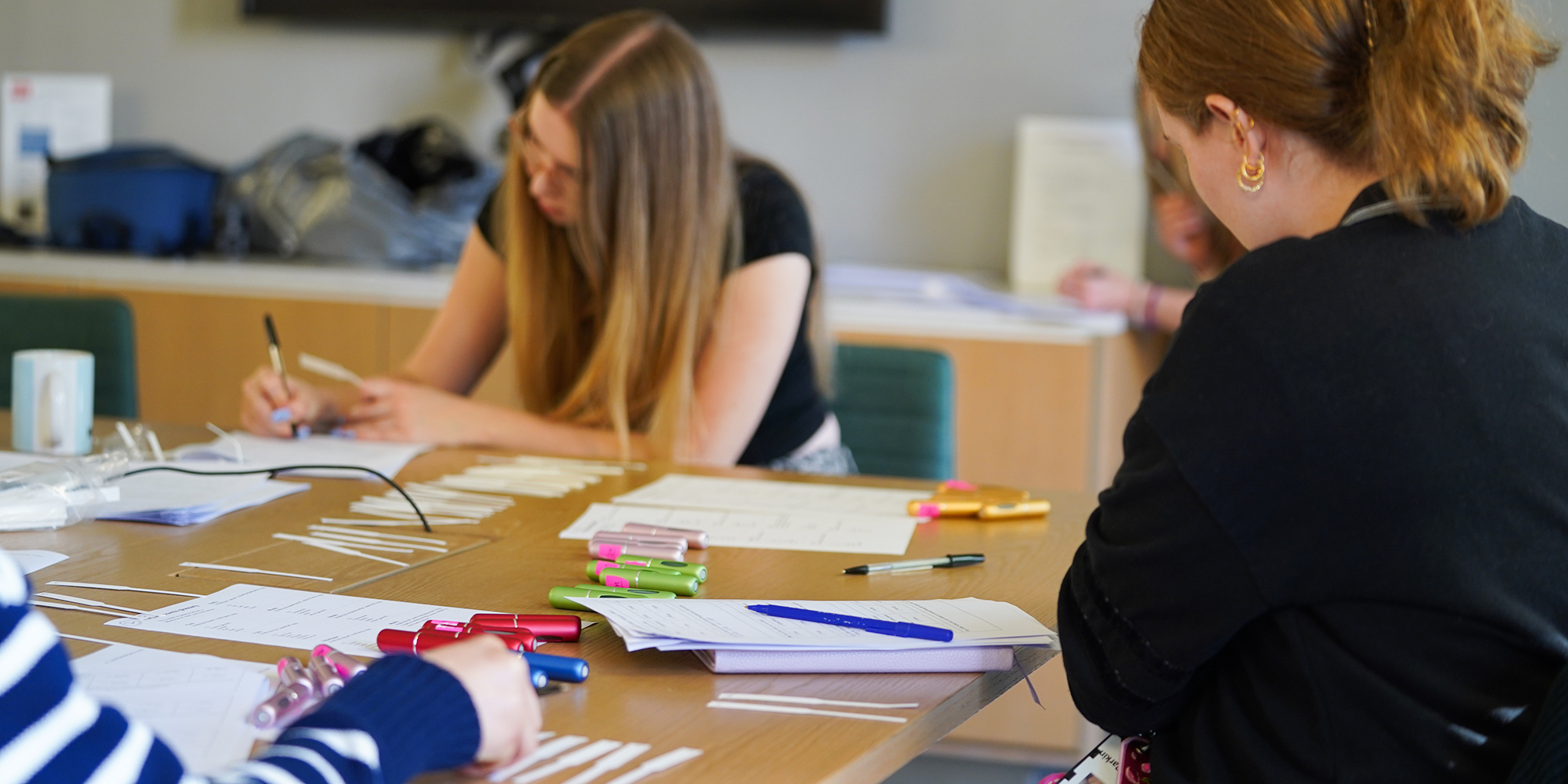 Two women in black shirts testing perfumes for Which? 