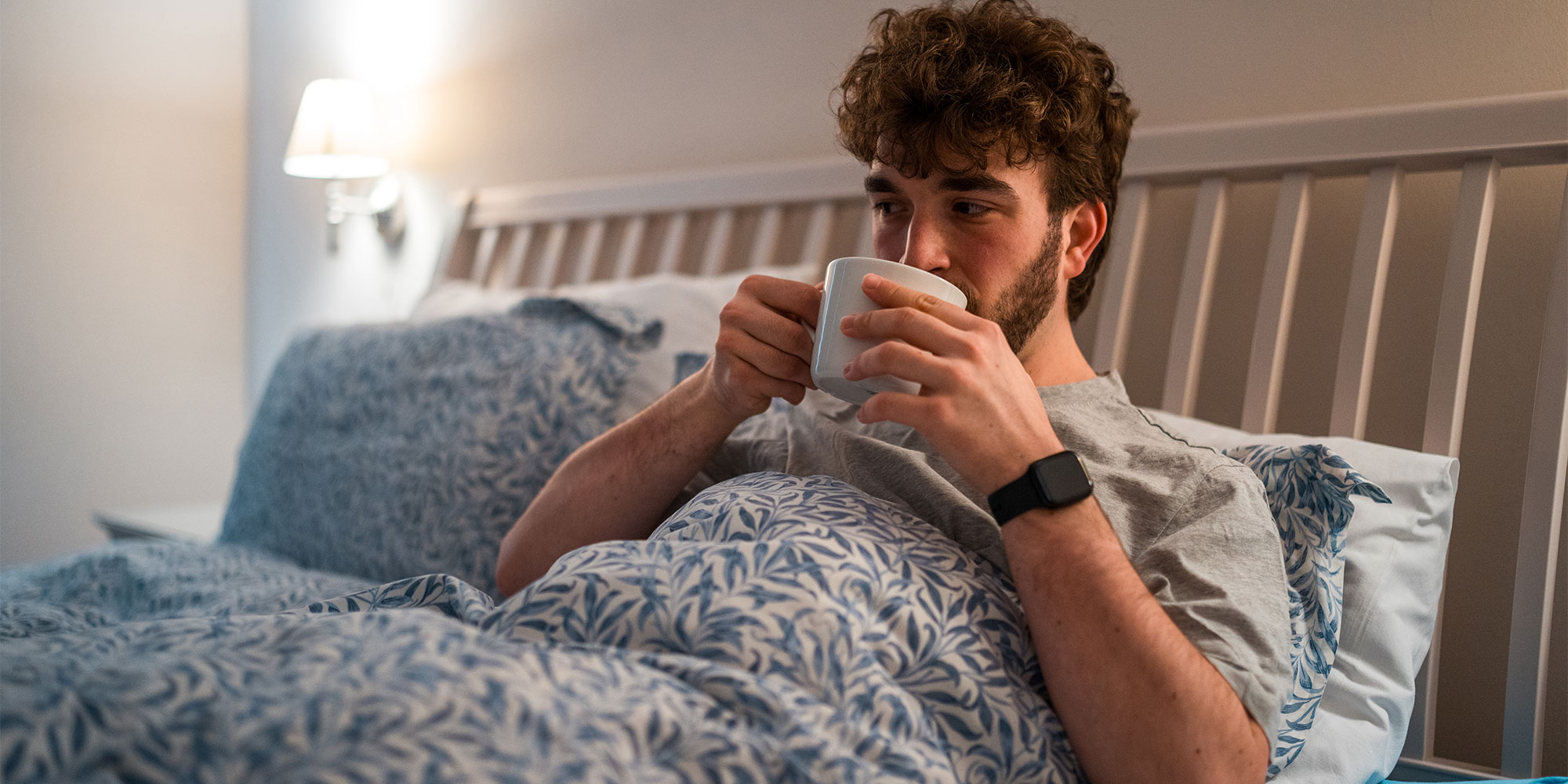 A man drinking a bedtime tea or drink in bed 
