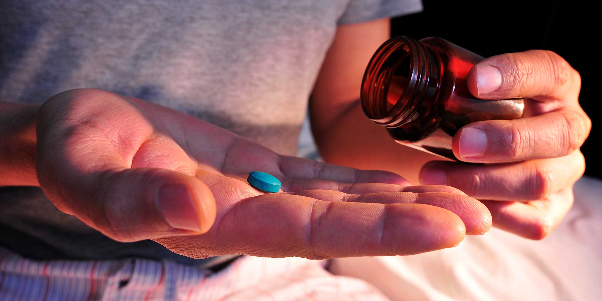 hand holding blue pill