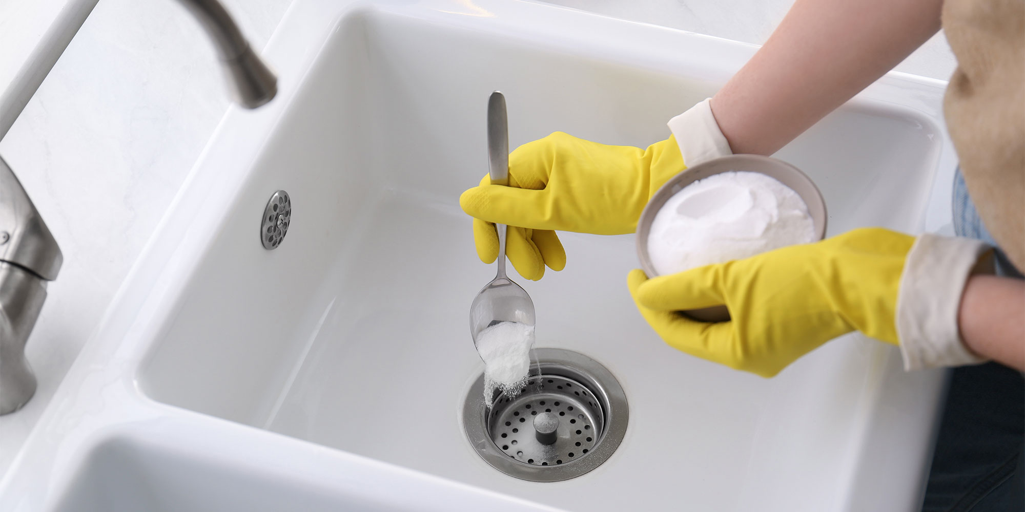 person cleaning a sink with bicarbonate of soda
