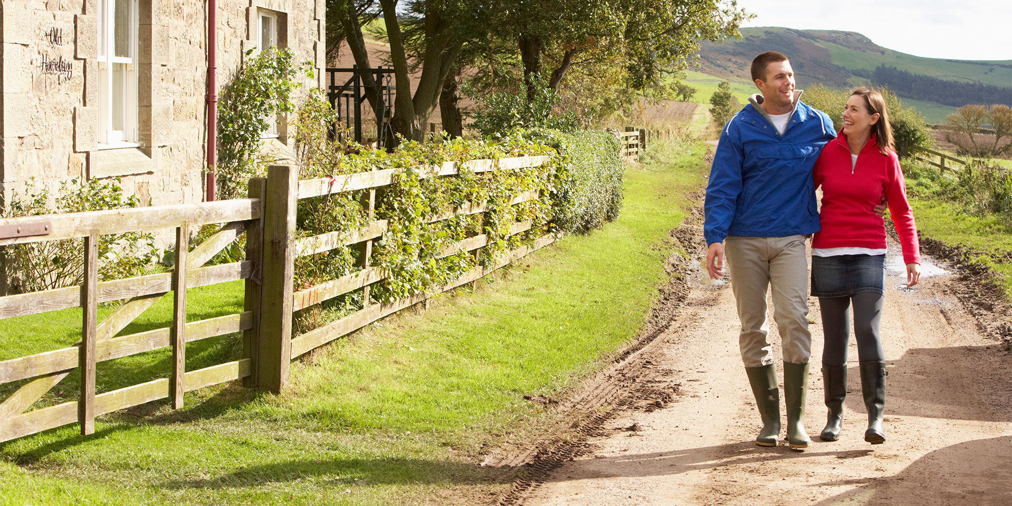 A couple wearing the best wellington boots for 2025 on a country walk