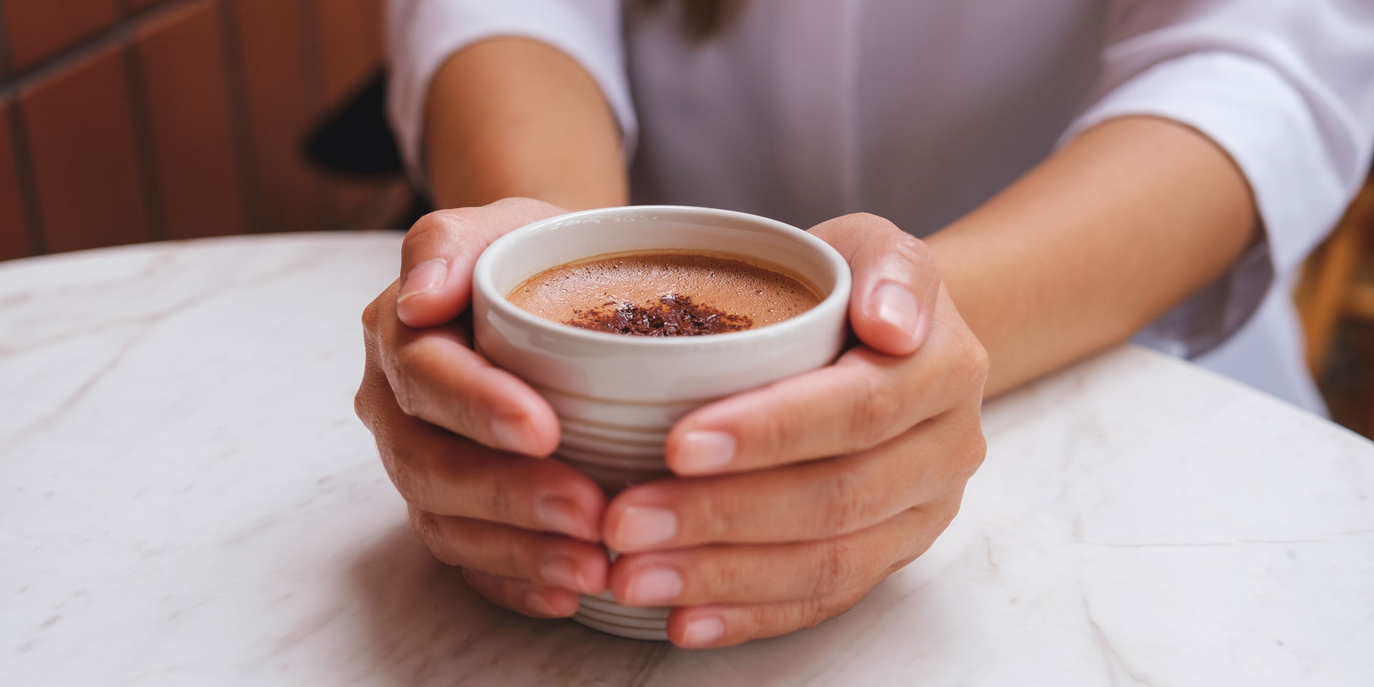 someone holding a mug of hot chocolate