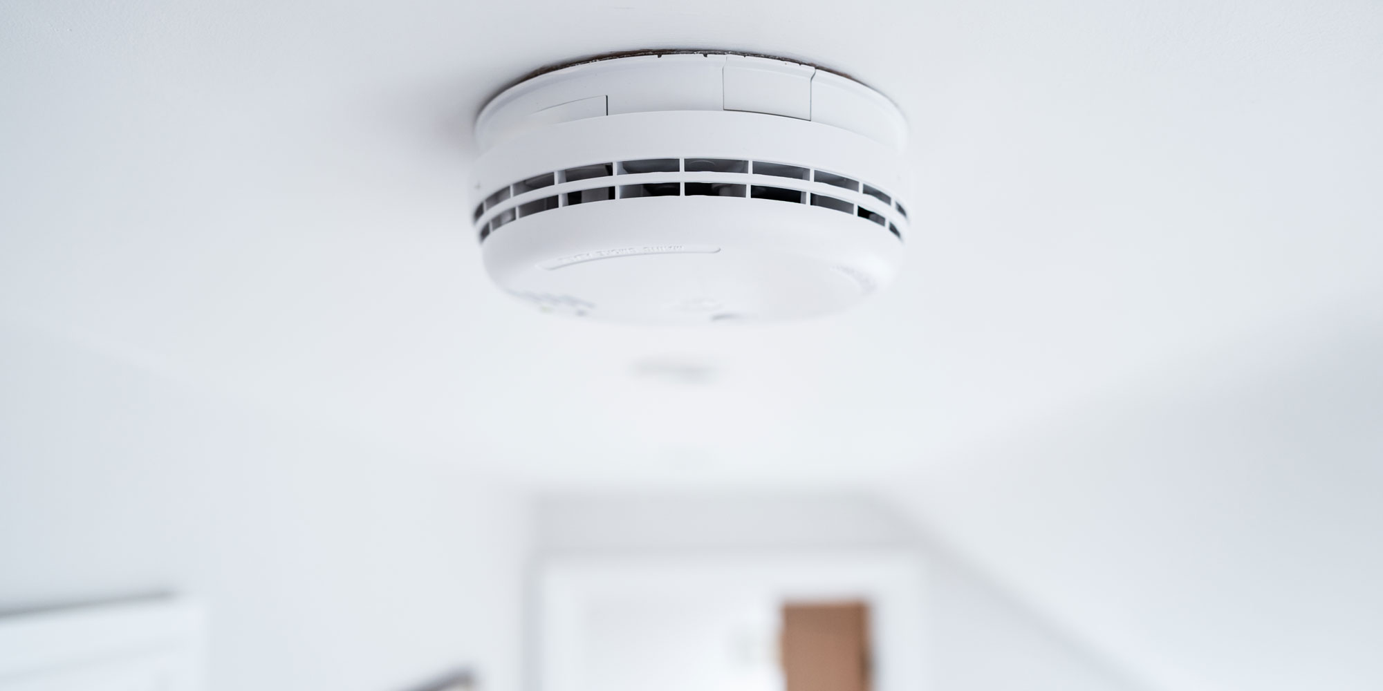 A smoke alarm mounted on a ceiling