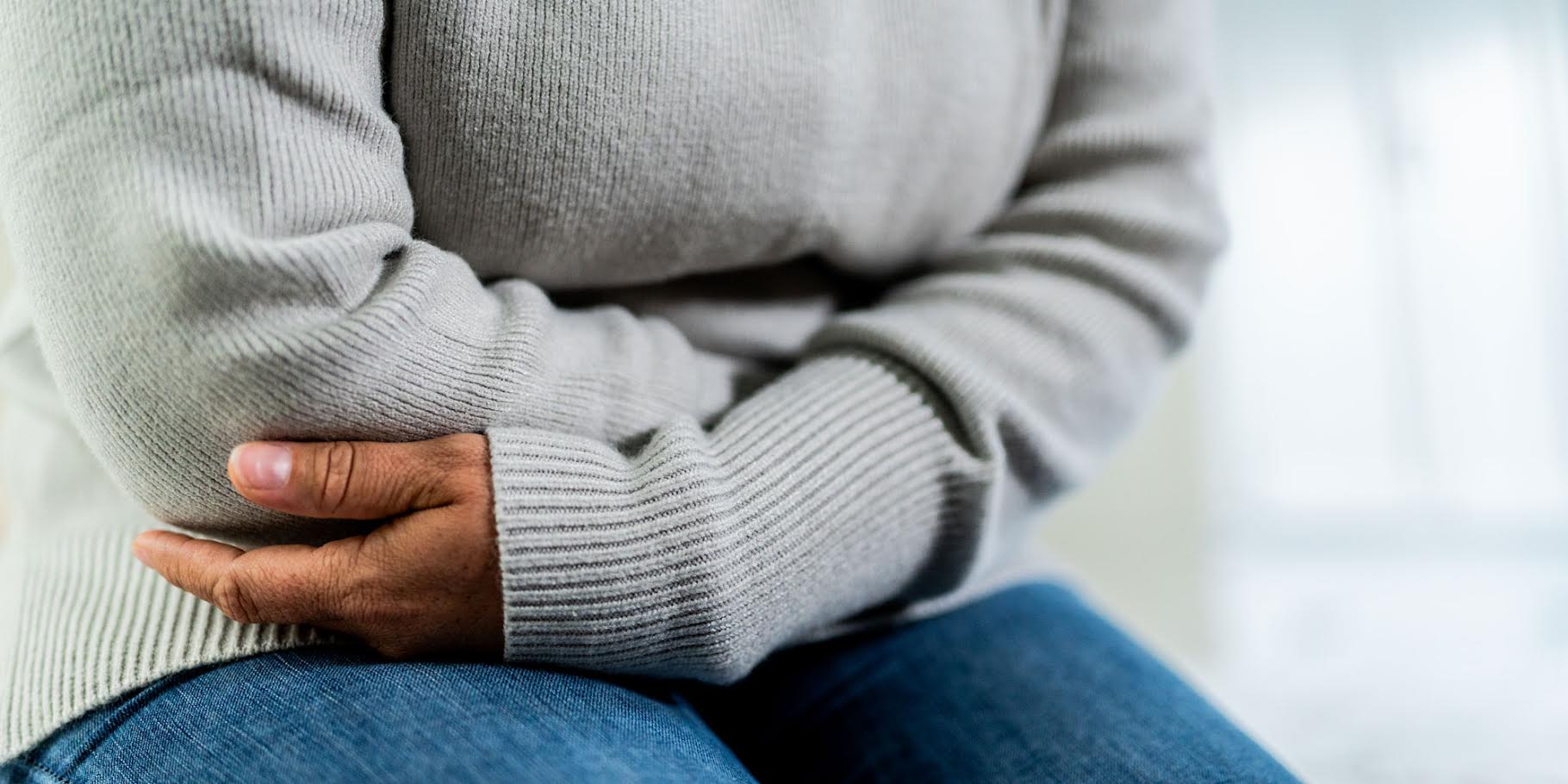 person sitting holding their stomach
