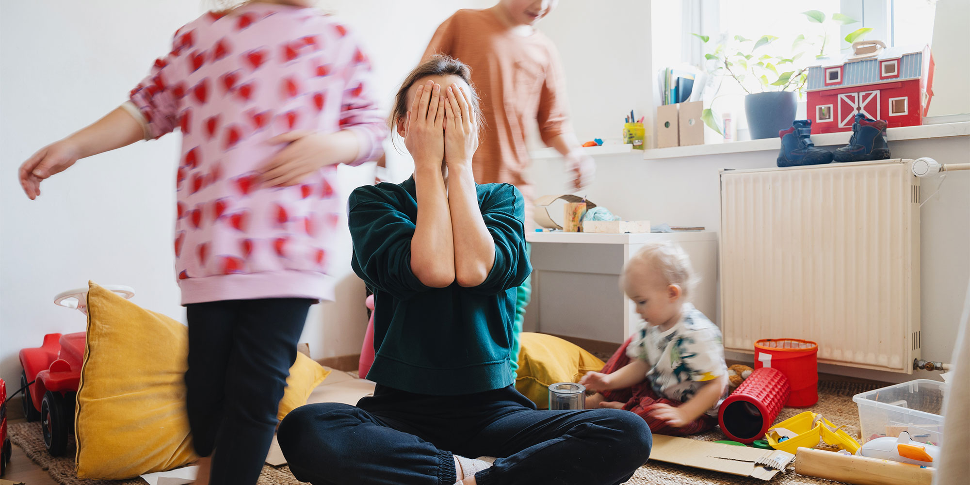 A very stressed woman surrounded by chaotic family