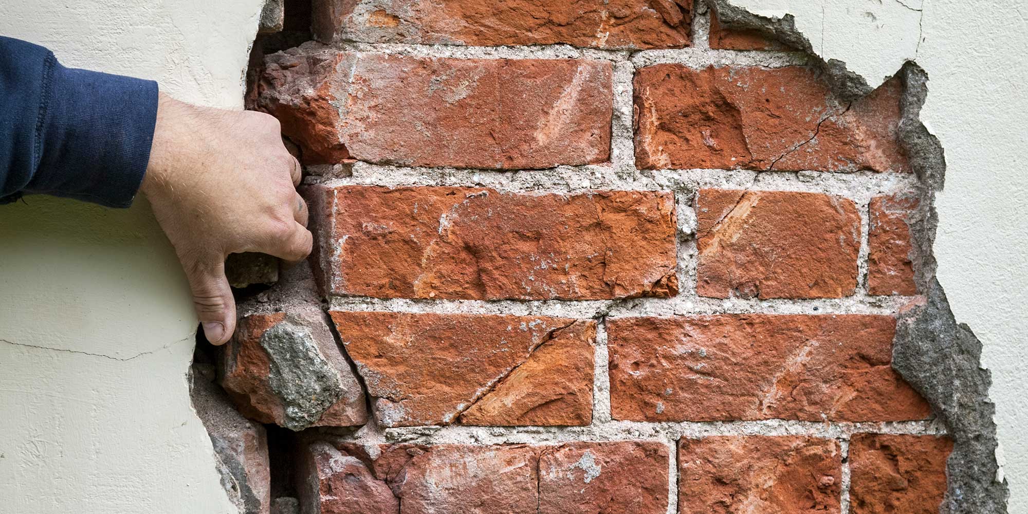 damp damage on a wall with exposed bricks