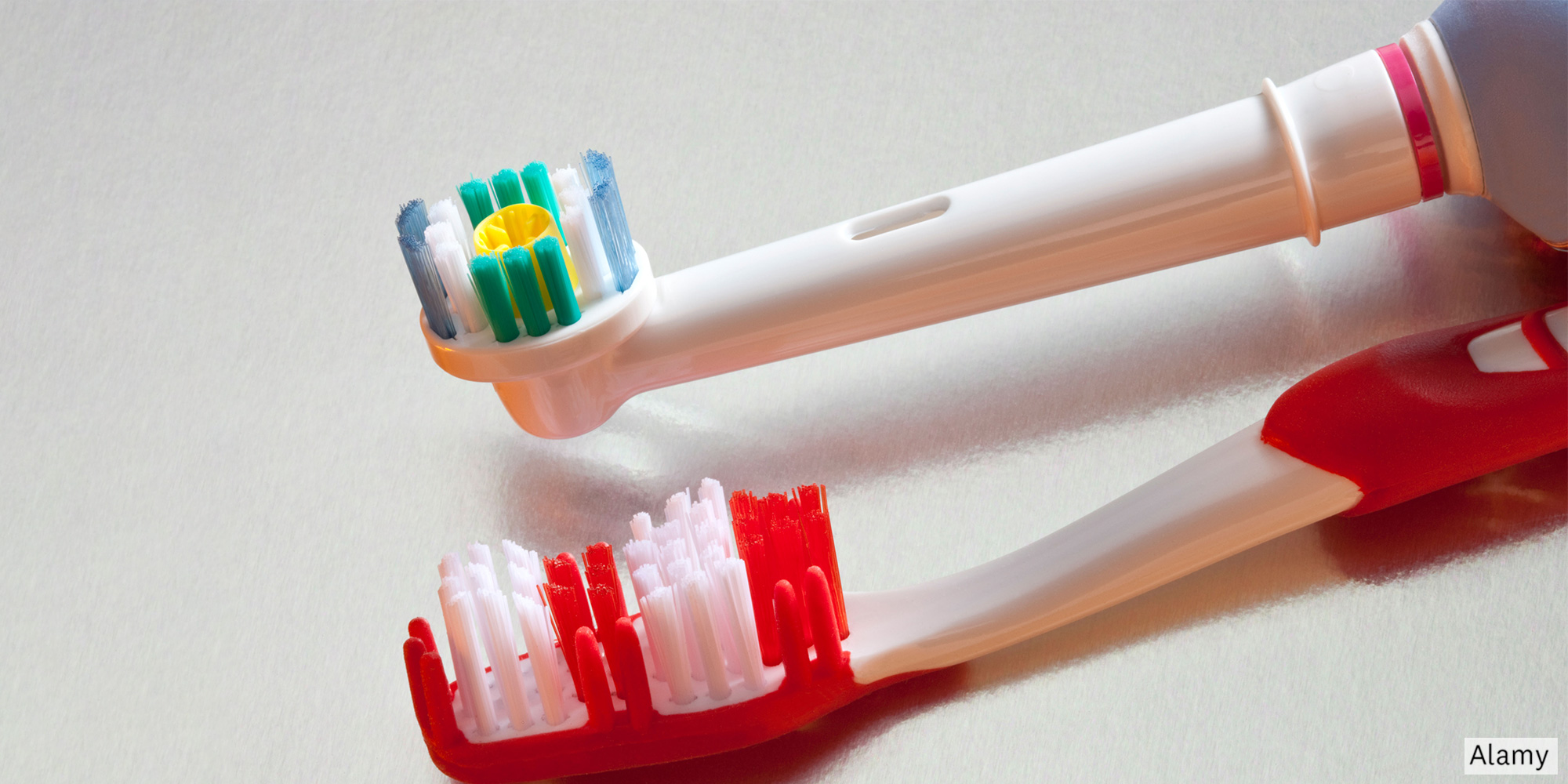A manual and an electric toothbrush side by side