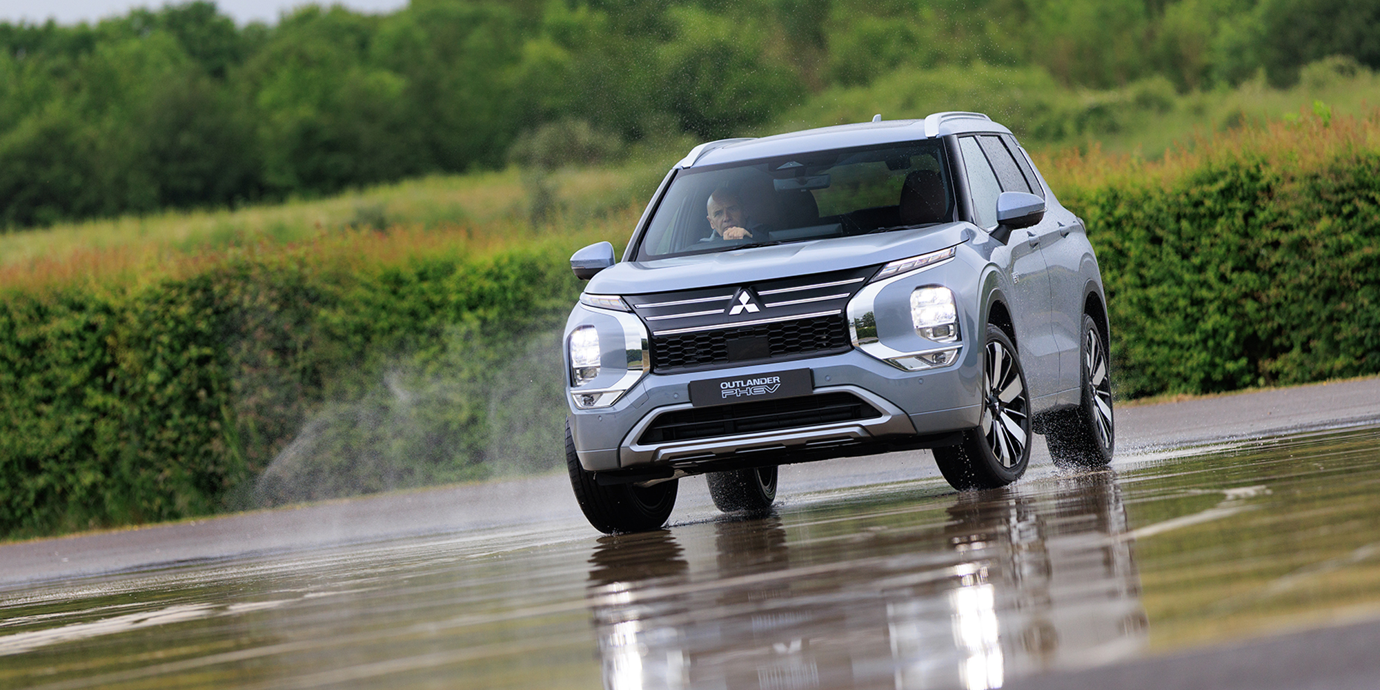 Mitsubishi Outlander PHEV being driven on a wet road