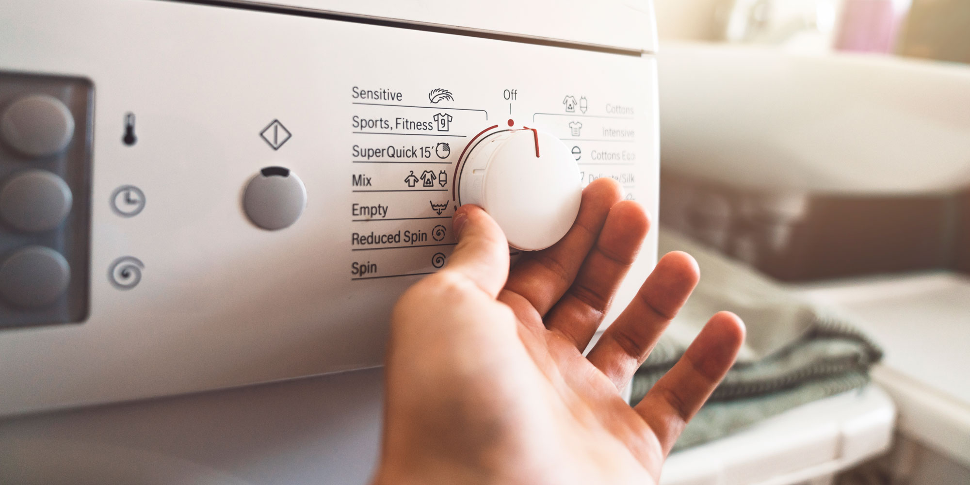 Hand turning washing machine dial