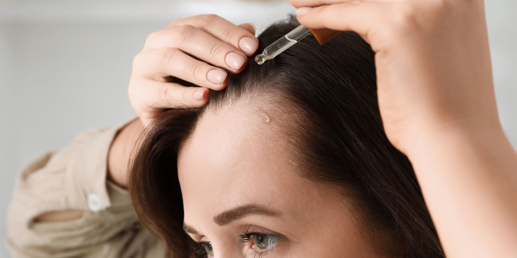Woman applying hair serum