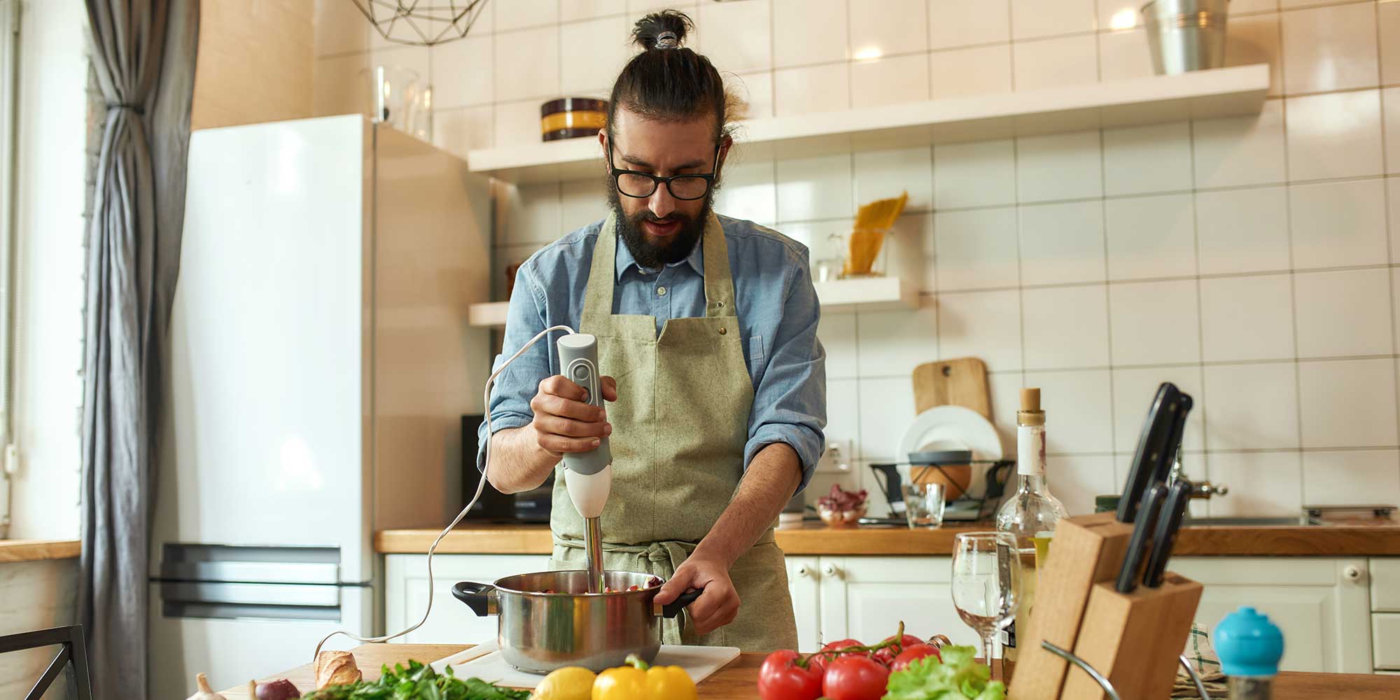 person using a hand blender in the kitchen