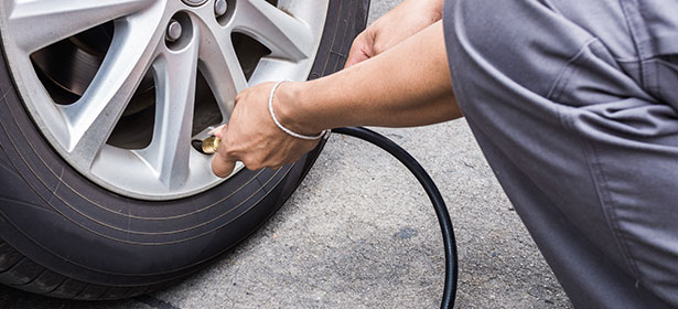 Checking tyre pressure on a car