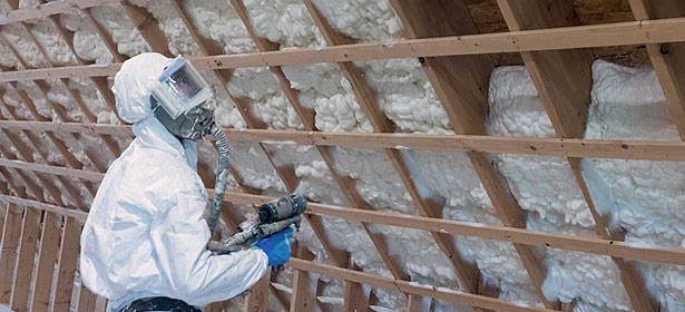 Installer spraying foam insulation into place