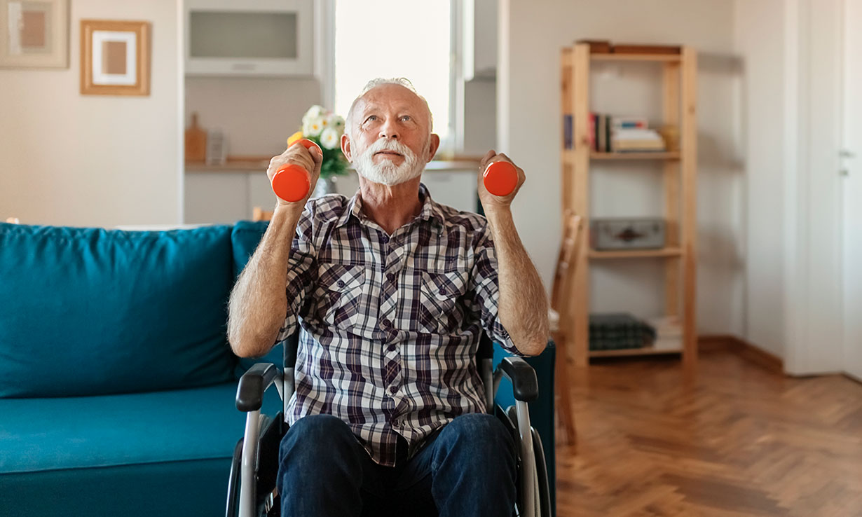 Man in wheelchair lifting weights at home