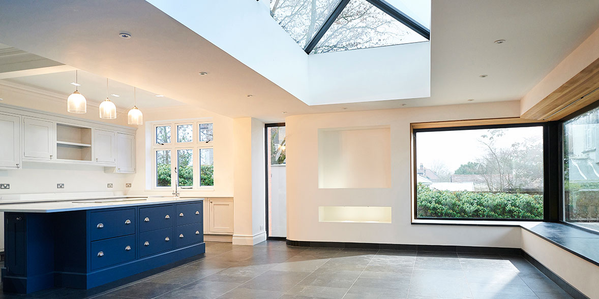 Blue kitchen with skylight and wooden floor